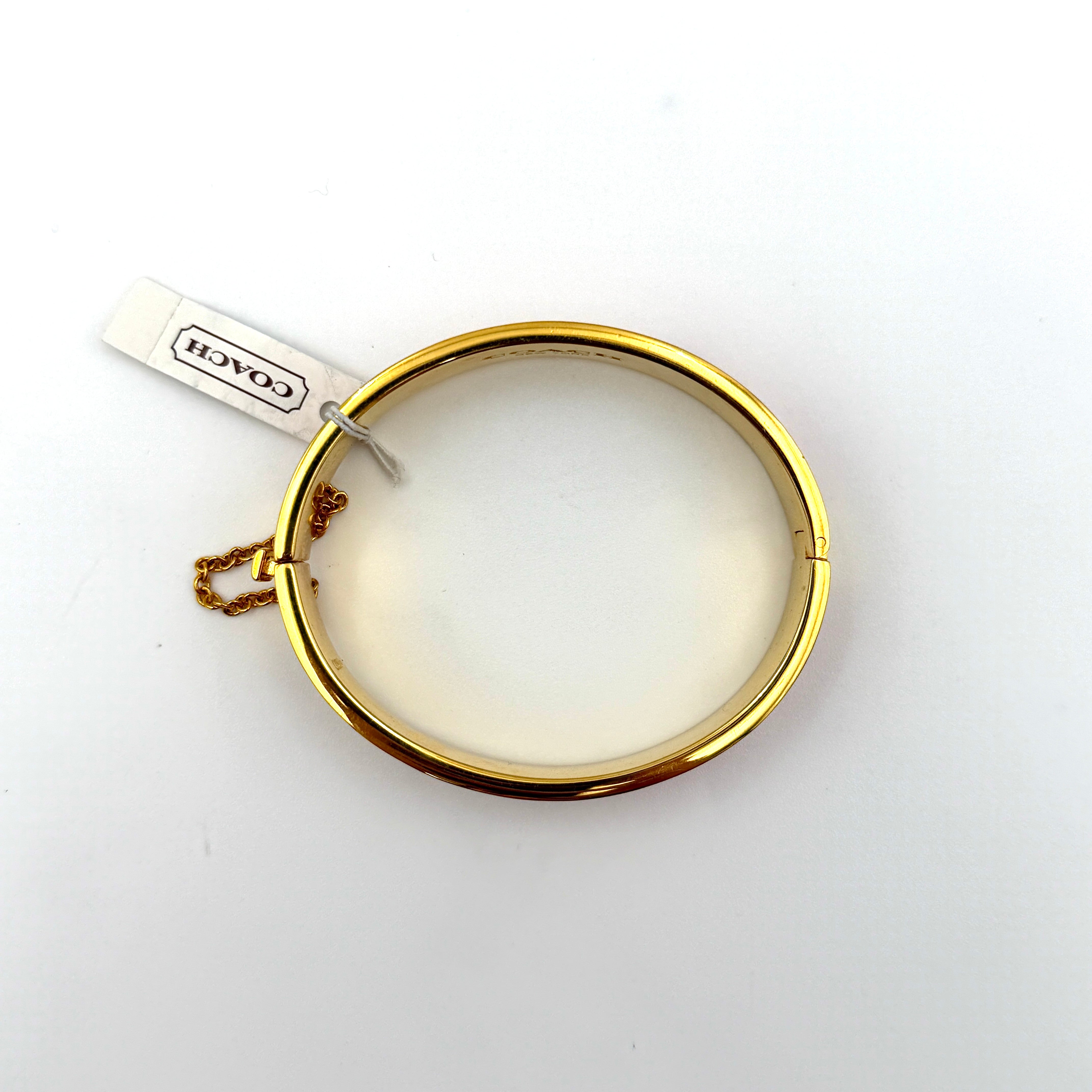 Coach Signature C Bangle Bracelet in gold-tone metal with red enamel, featuring the signature C motif and safety chain.