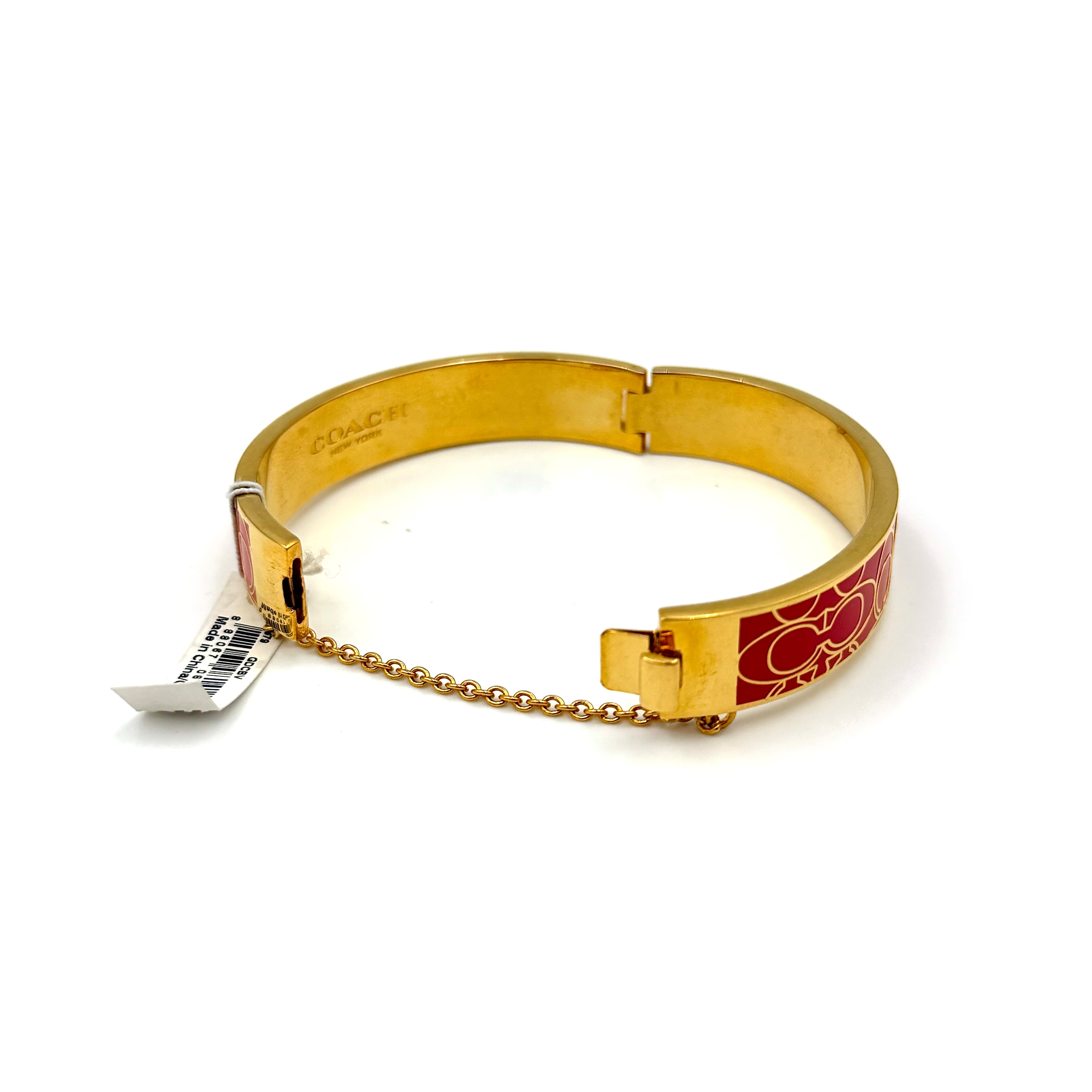 Coach Signature C Bangle Bracelet in gold-tone metal with red enamel, featuring the signature C motif and safety chain.
