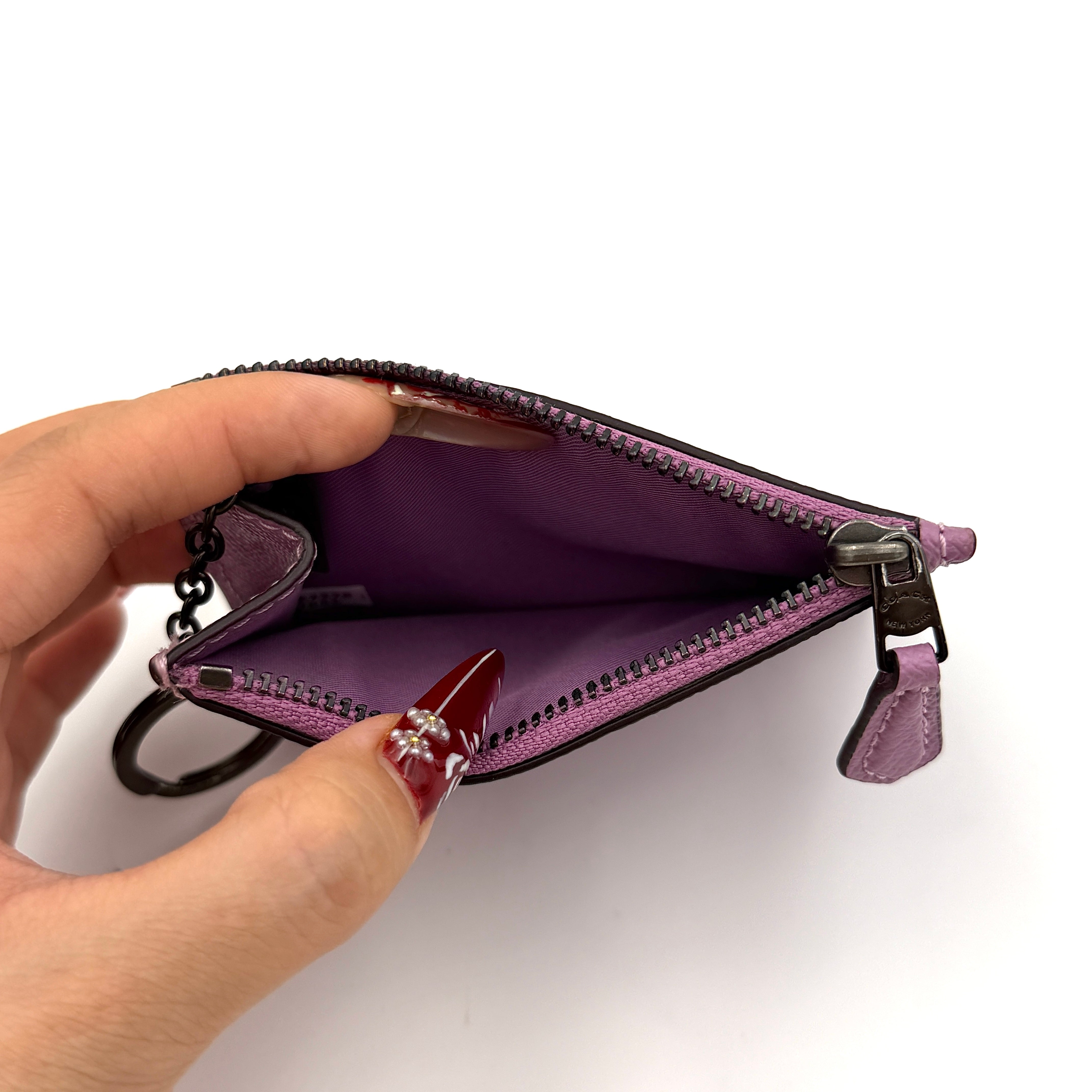 Coach Mini Skinny ID Case in purple pebbled leather with black hardware, featuring a zip closure and key ring.