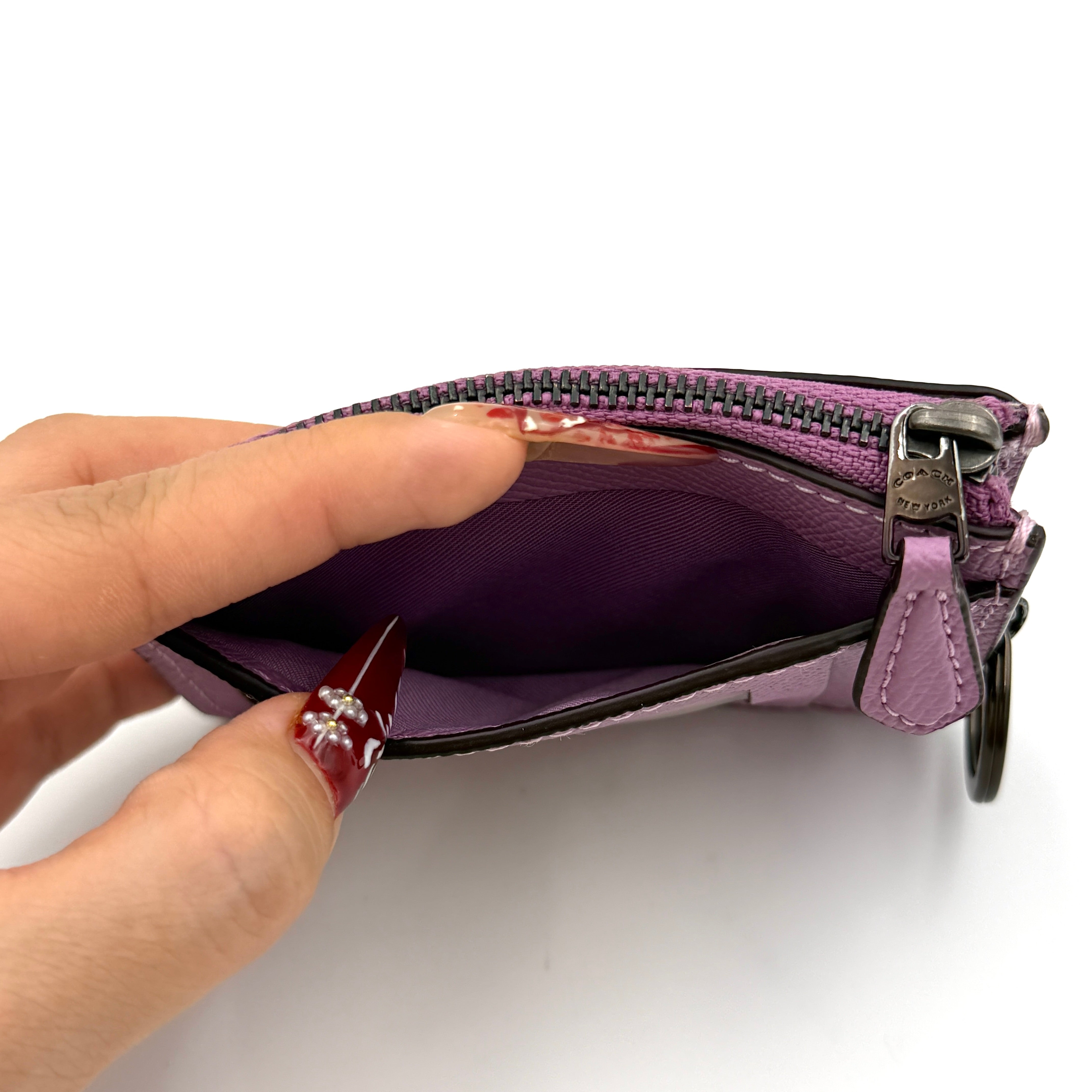 Coach Mini Skinny ID Case in purple pebbled leather with black hardware, featuring a zip closure and key ring.