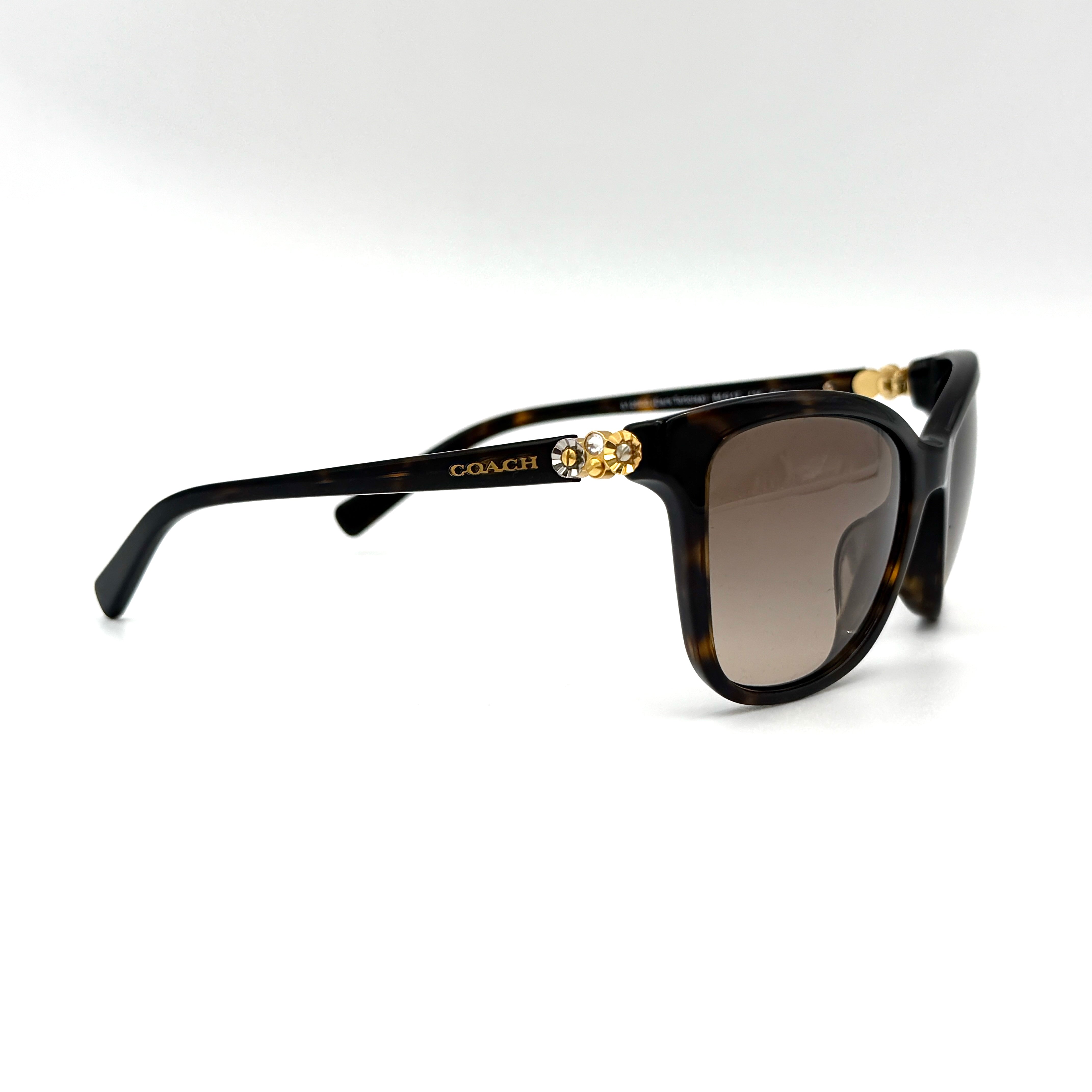 Coach HC8187BF sunglasses in dark tortoise acetate with gold floral and crystal temple detailing, shown in a three-quarter profile.