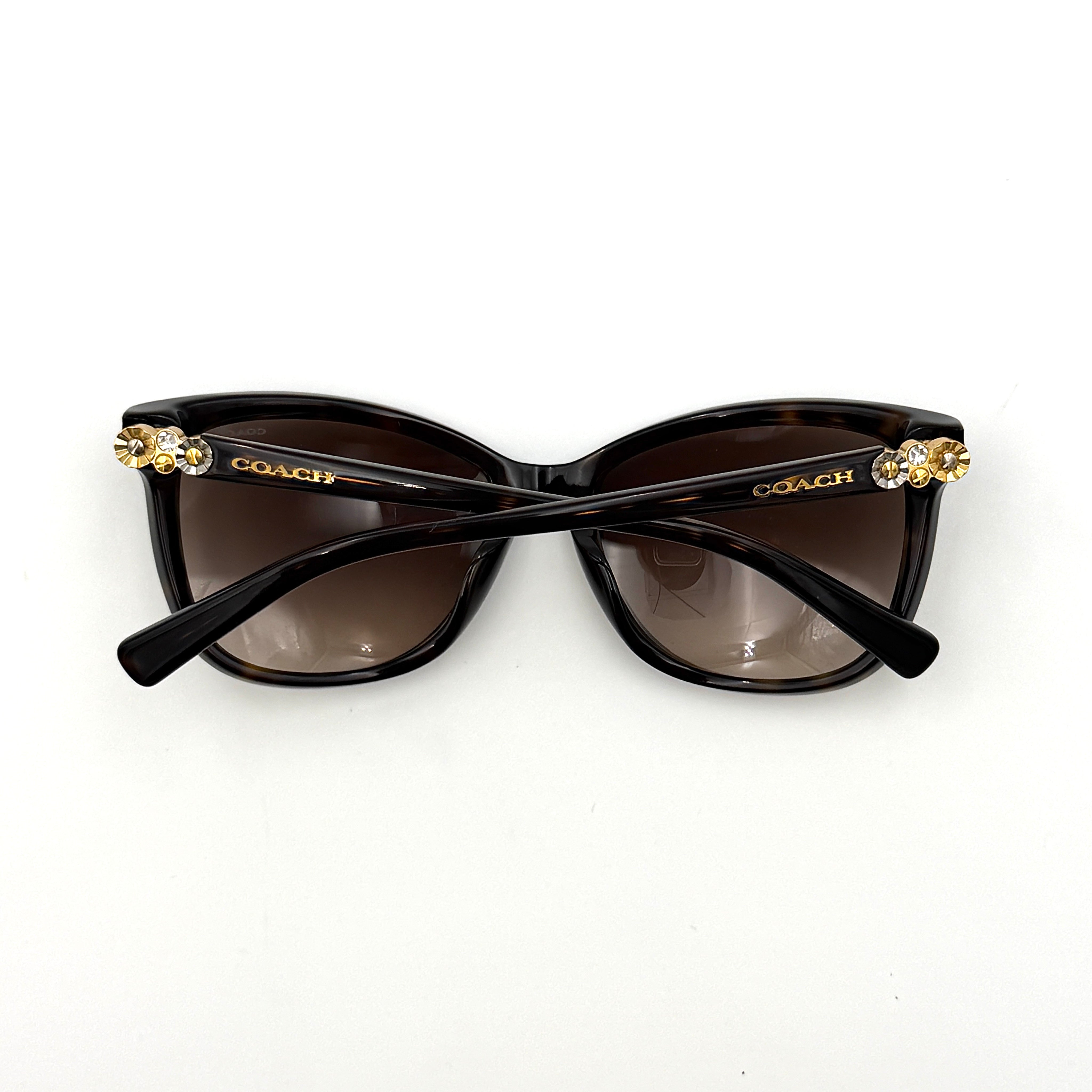 Coach HC8187BF sunglasses in dark tortoise acetate with gold floral and crystal temple detailing, shown in a three-quarter profile.