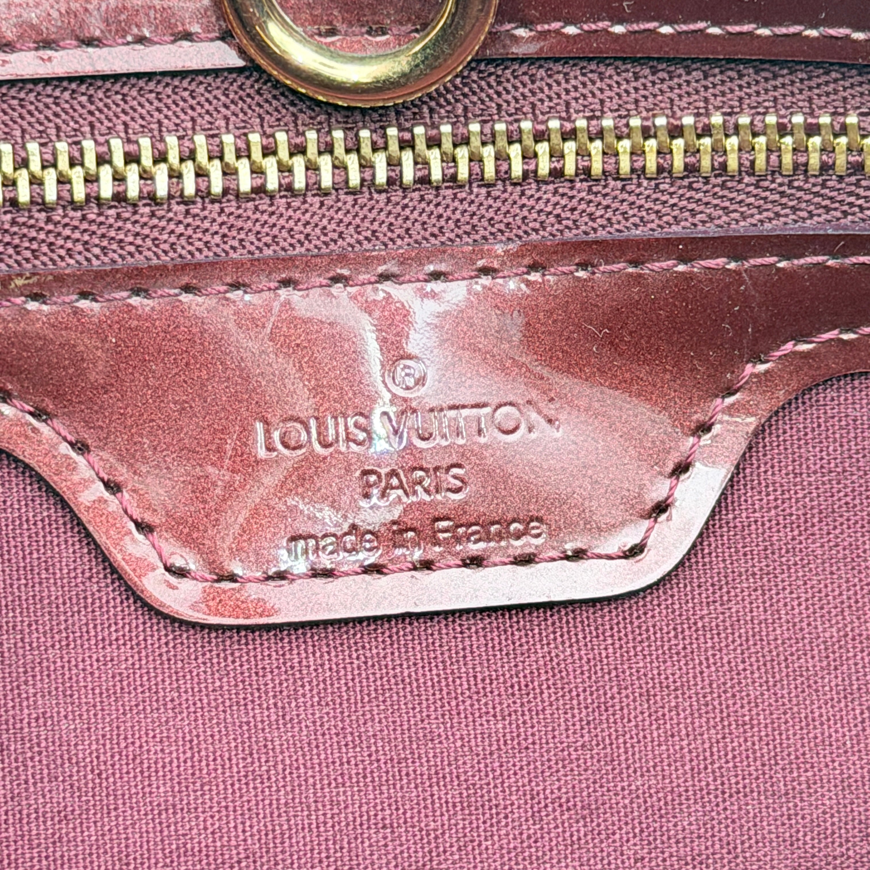 Louis Vuitton Wilshire PM Monogram Vernis bag in glossy deep red with gold nameplate and embossed monogram, displayed against a clean background.
