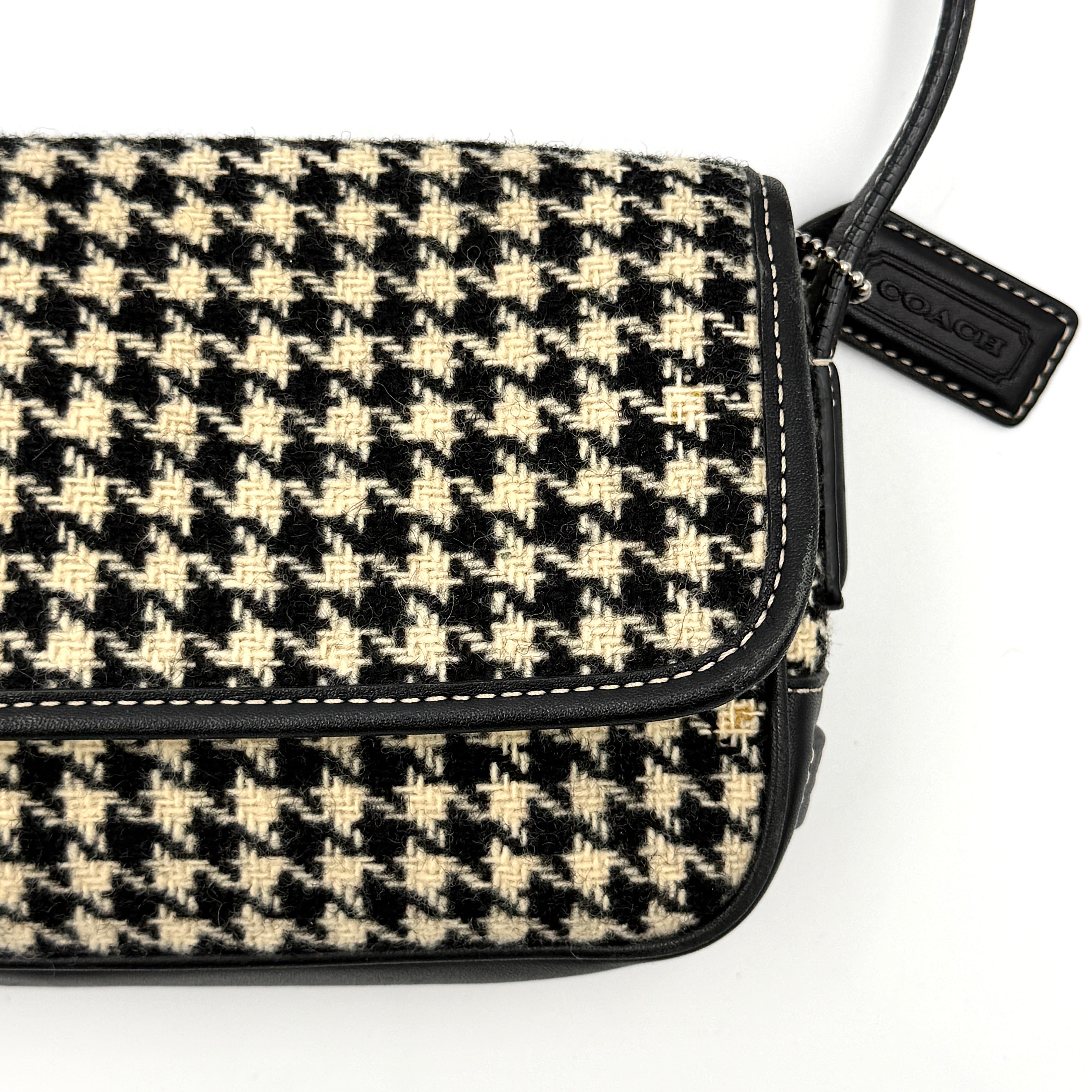 Coach Y2K shoulder bag with a bold black and cream houndstooth pattern and sleek leather trim.