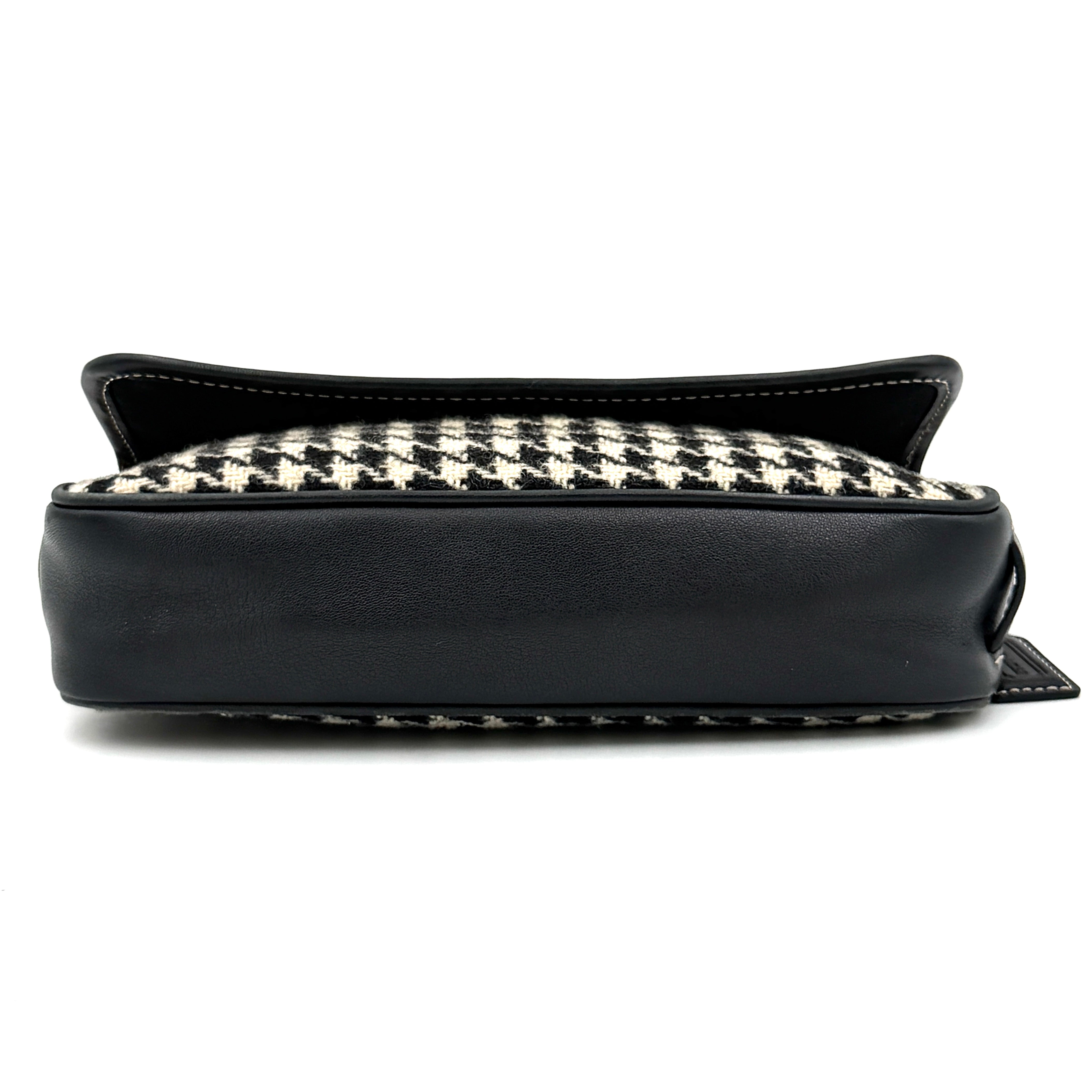 Coach Y2K shoulder bag with a bold black and cream houndstooth pattern and sleek leather trim.