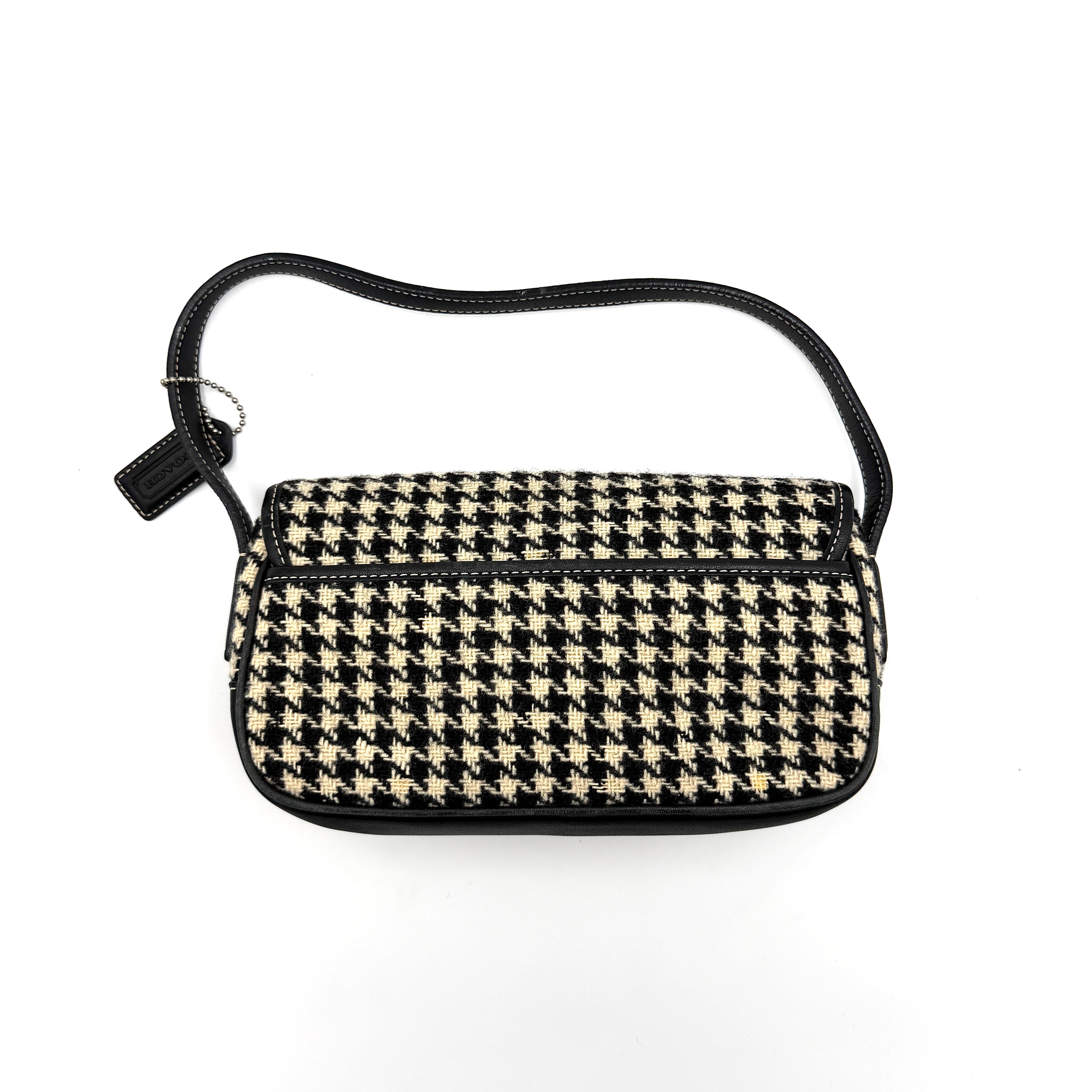 Coach Y2K shoulder bag with a bold black and cream houndstooth pattern and sleek leather trim.