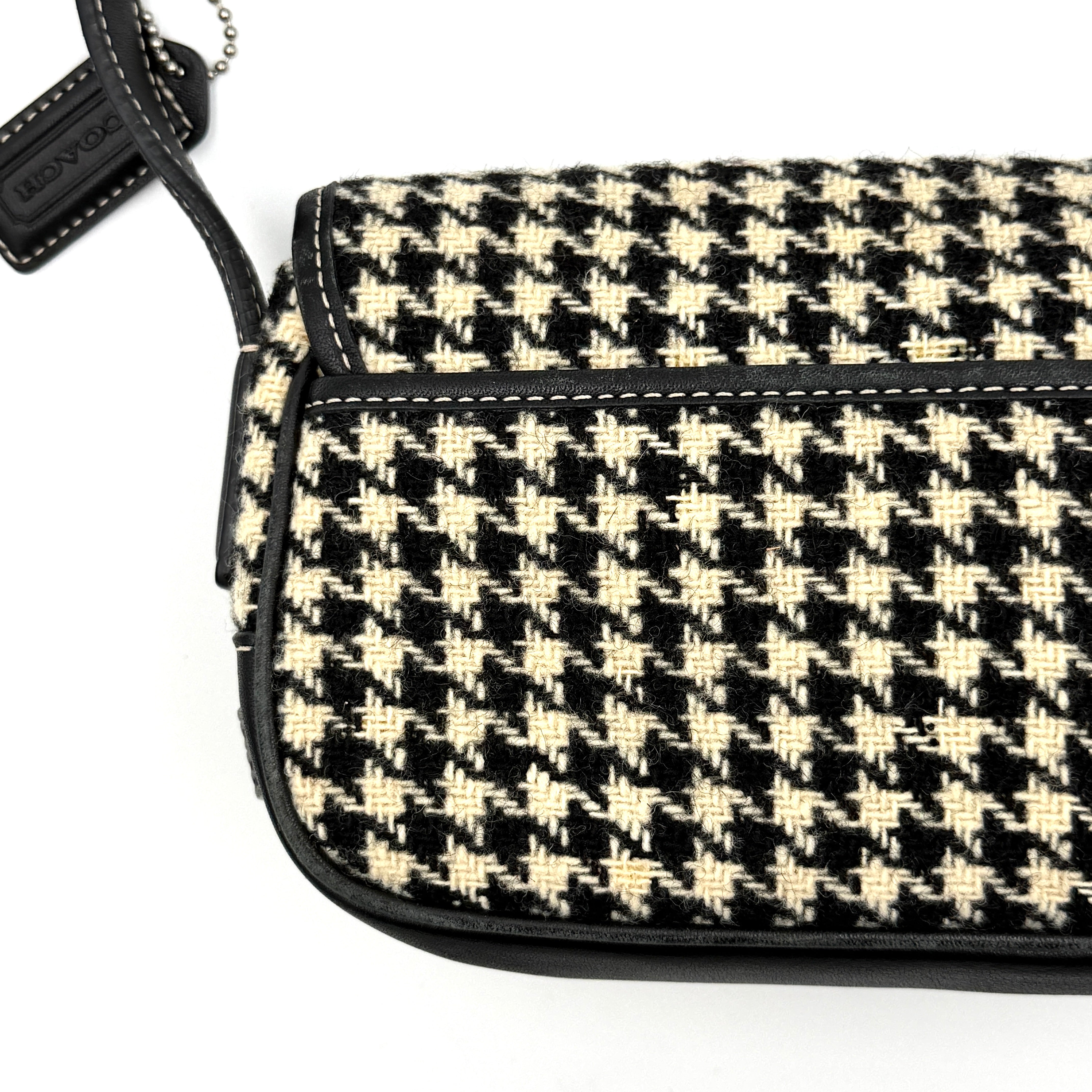 Coach Y2K shoulder bag with a bold black and cream houndstooth pattern and sleek leather trim.
