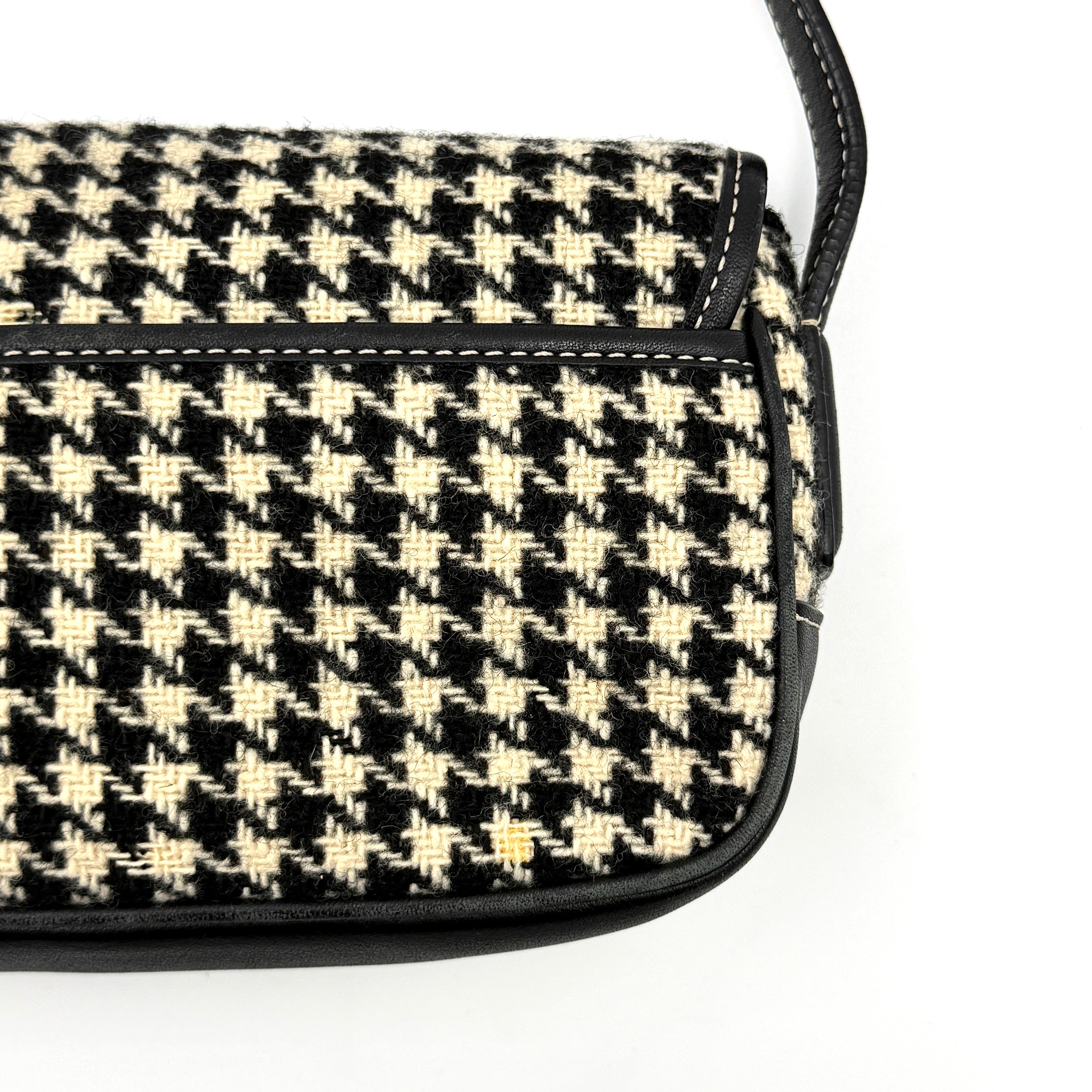 Coach Y2K shoulder bag with a bold black and cream houndstooth pattern and sleek leather trim.