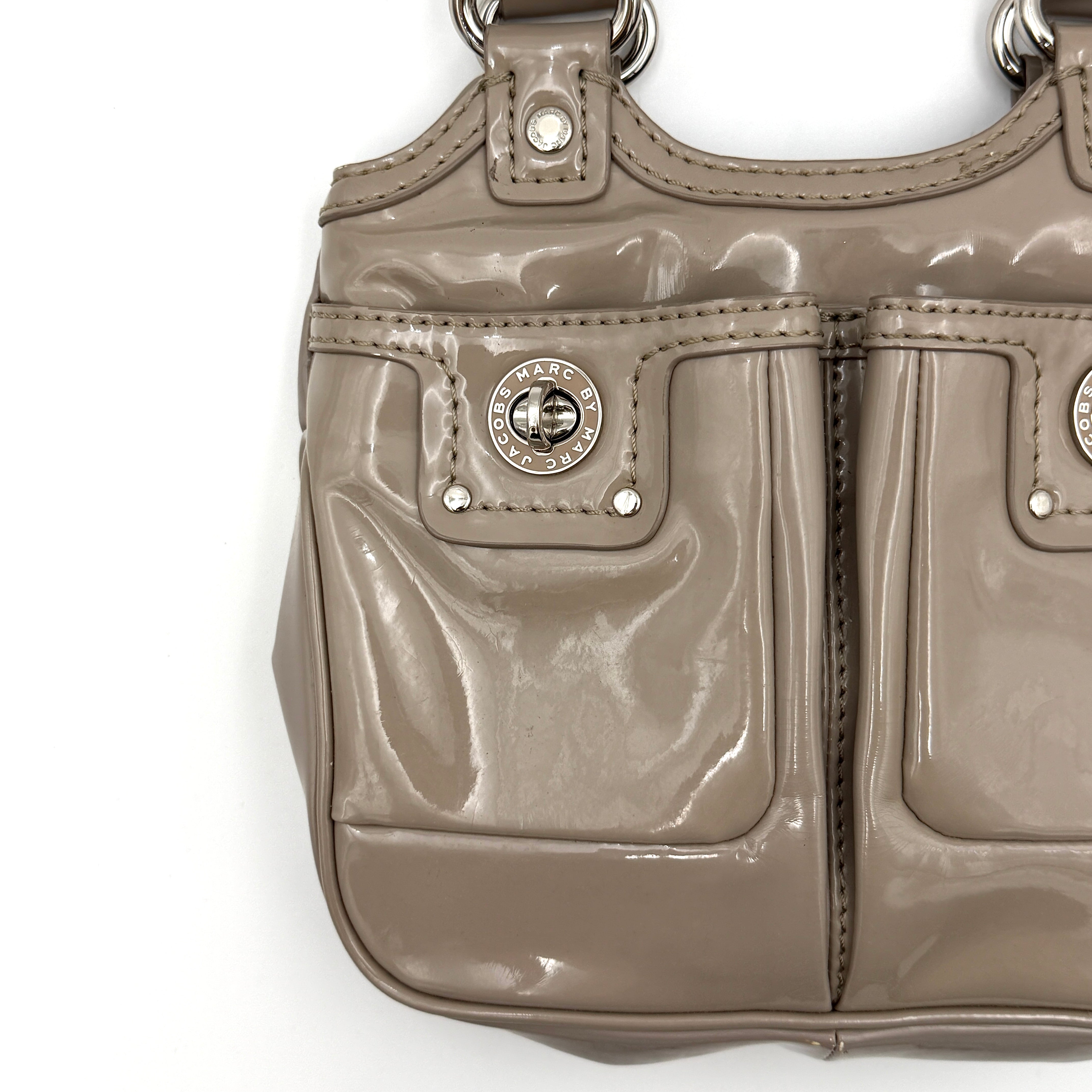 Marc Jacobs grey patent leather shoulder bag with double front turnlock pockets and structured dual handles.