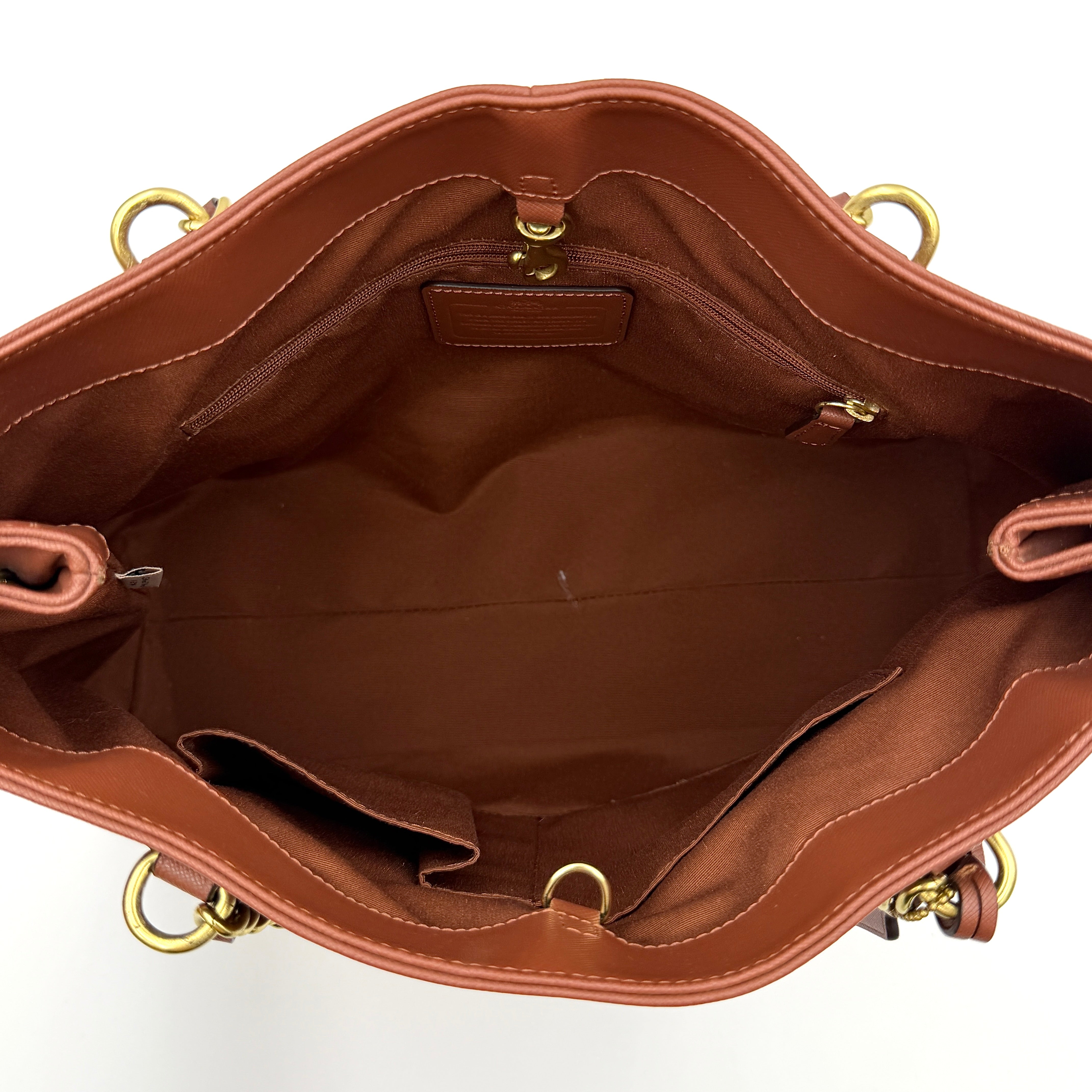 Coach Peyton Chain Shoulder Bag in brown leather with gold-tone chain handles, styled against a clean background.