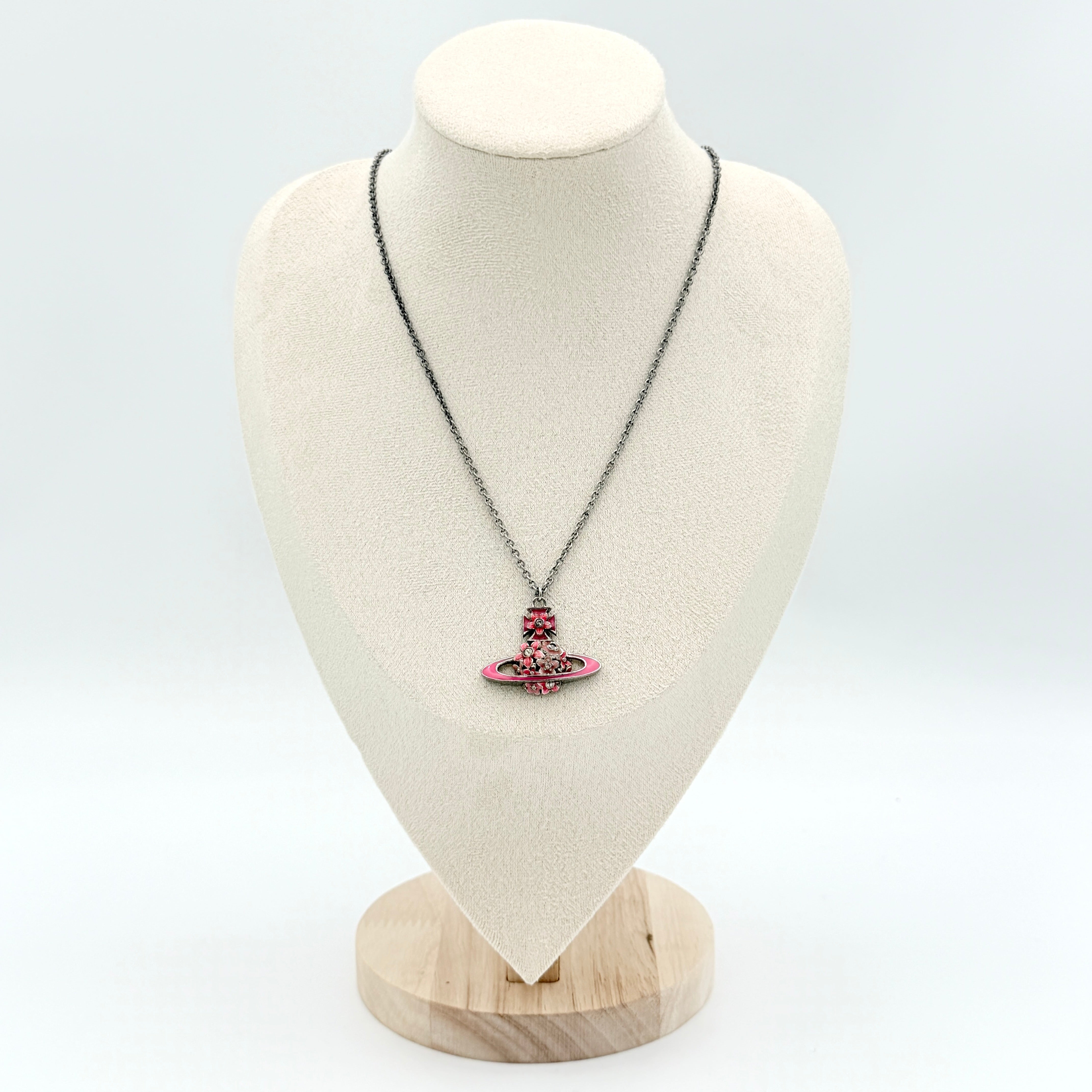 Vivienne Westwood Orb Flower Necklace in silver and pink displayed on a jewelry stand.