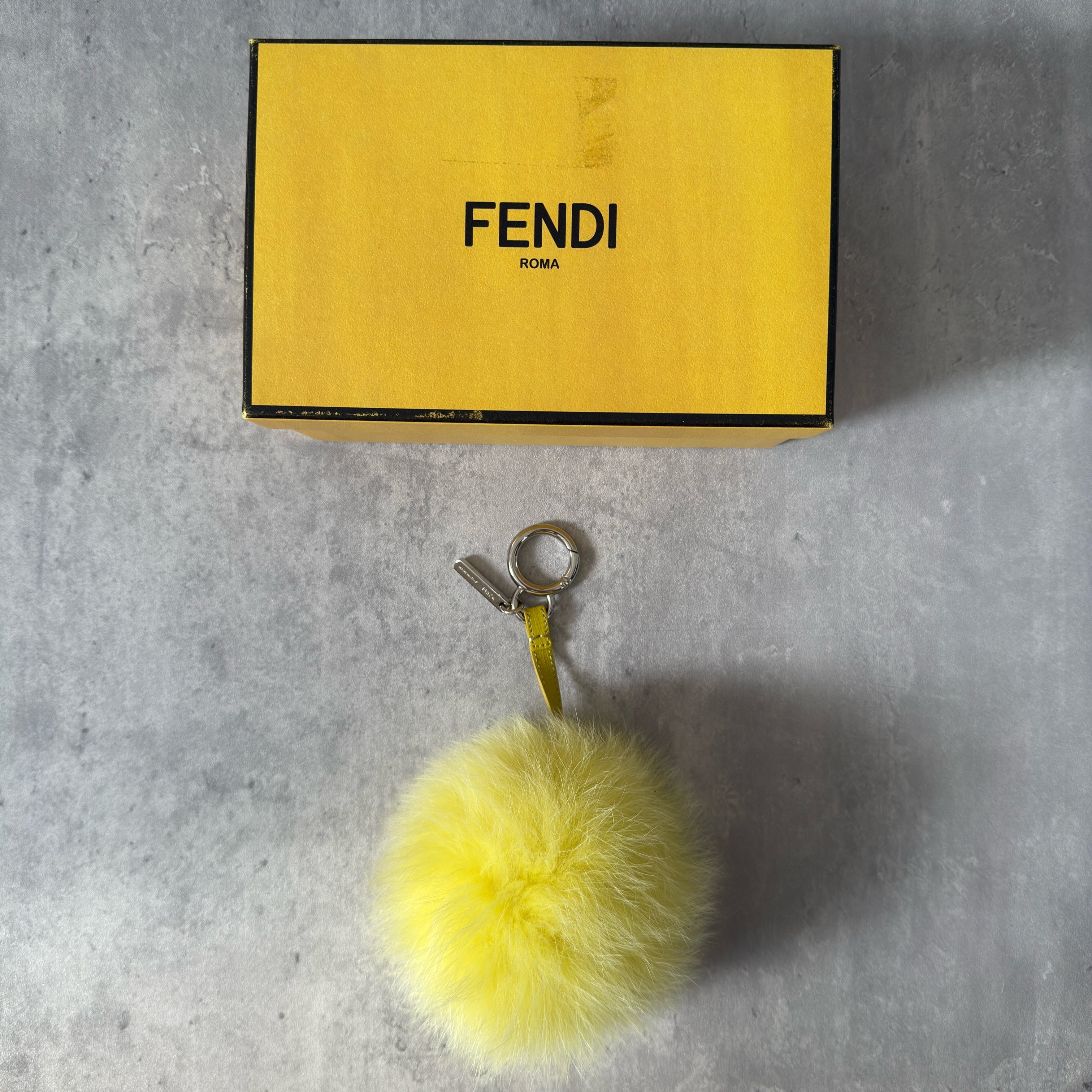 Fendi Yellow Fur Bag Charm with plush fox fur, silver-tone keyring, and leather strap.