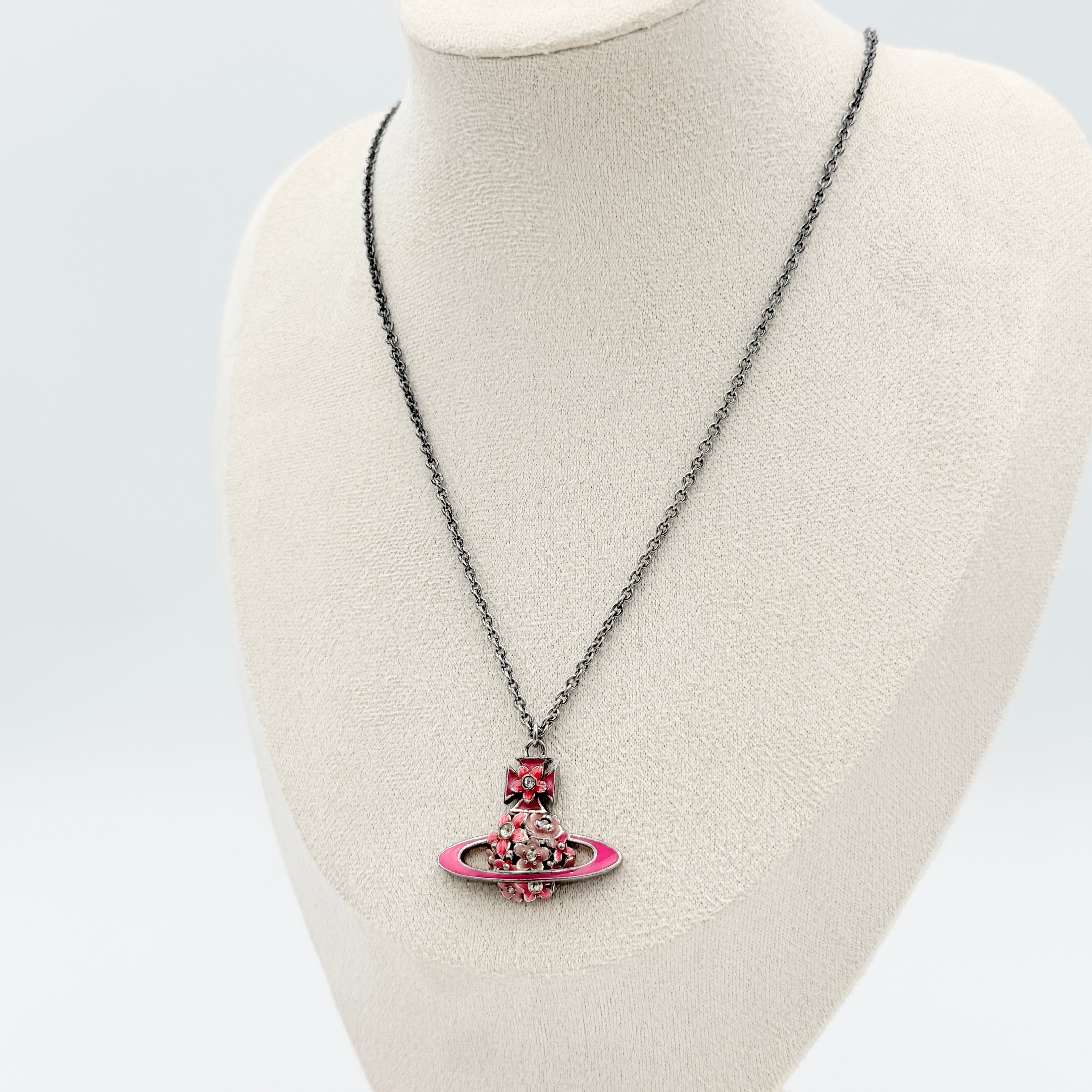 Vivienne Westwood Orb Flower Necklace in silver and pink displayed on a jewelry stand.