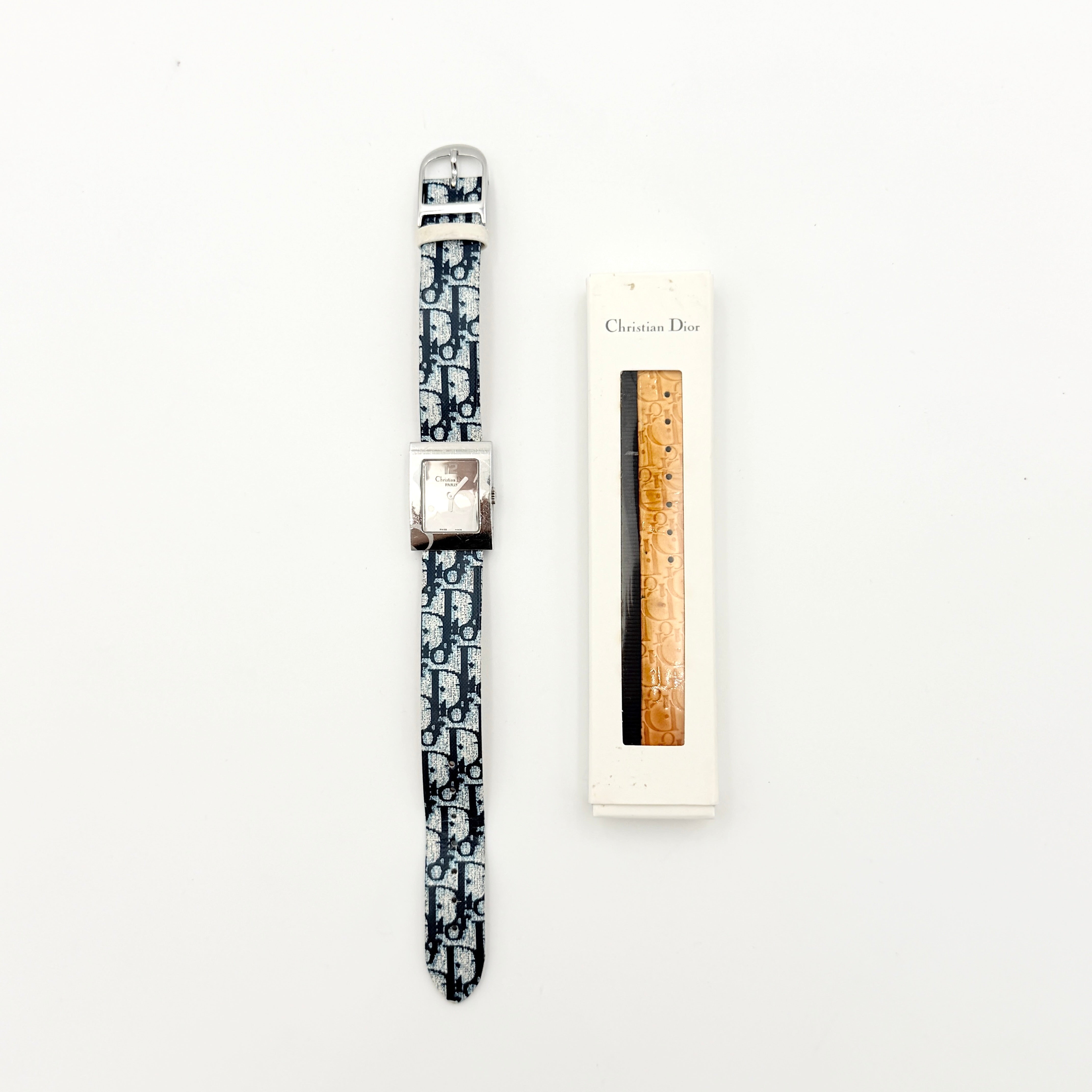 Dior Trotter Malice Watch with blue monogram strap and extra interchangeable yellow and black straps displayed.