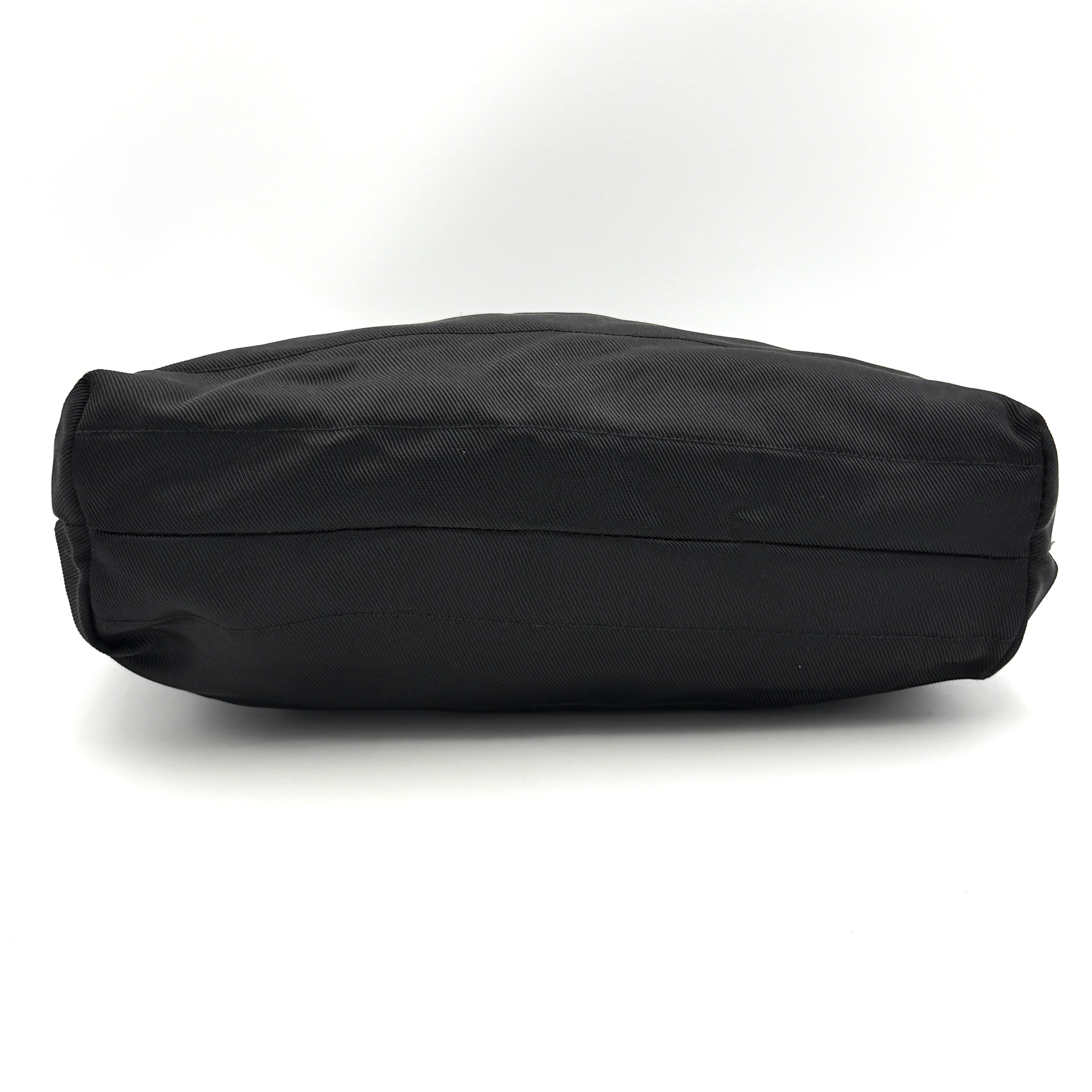 A classic black Gucci nylon tote bag with leather handles and gold-tone hardware displayed upright against a clean background.
