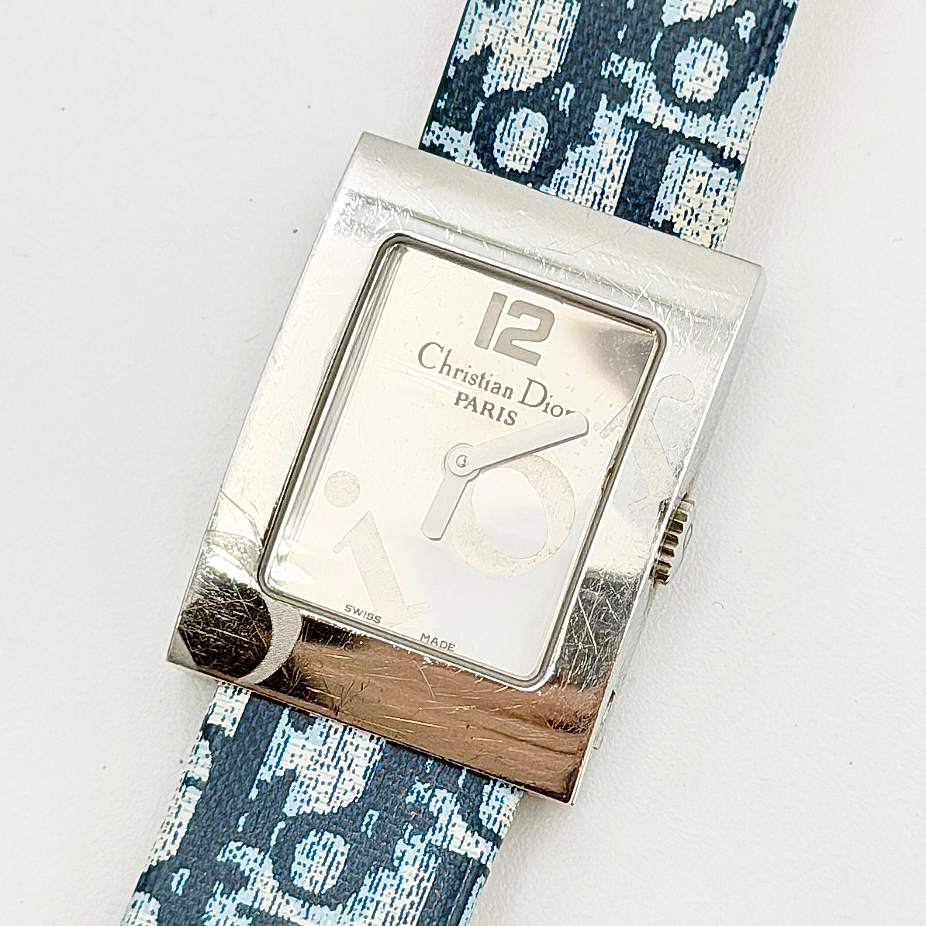 Dior Trotter Malice Watch with blue monogram strap and extra interchangeable yellow and black straps displayed.
