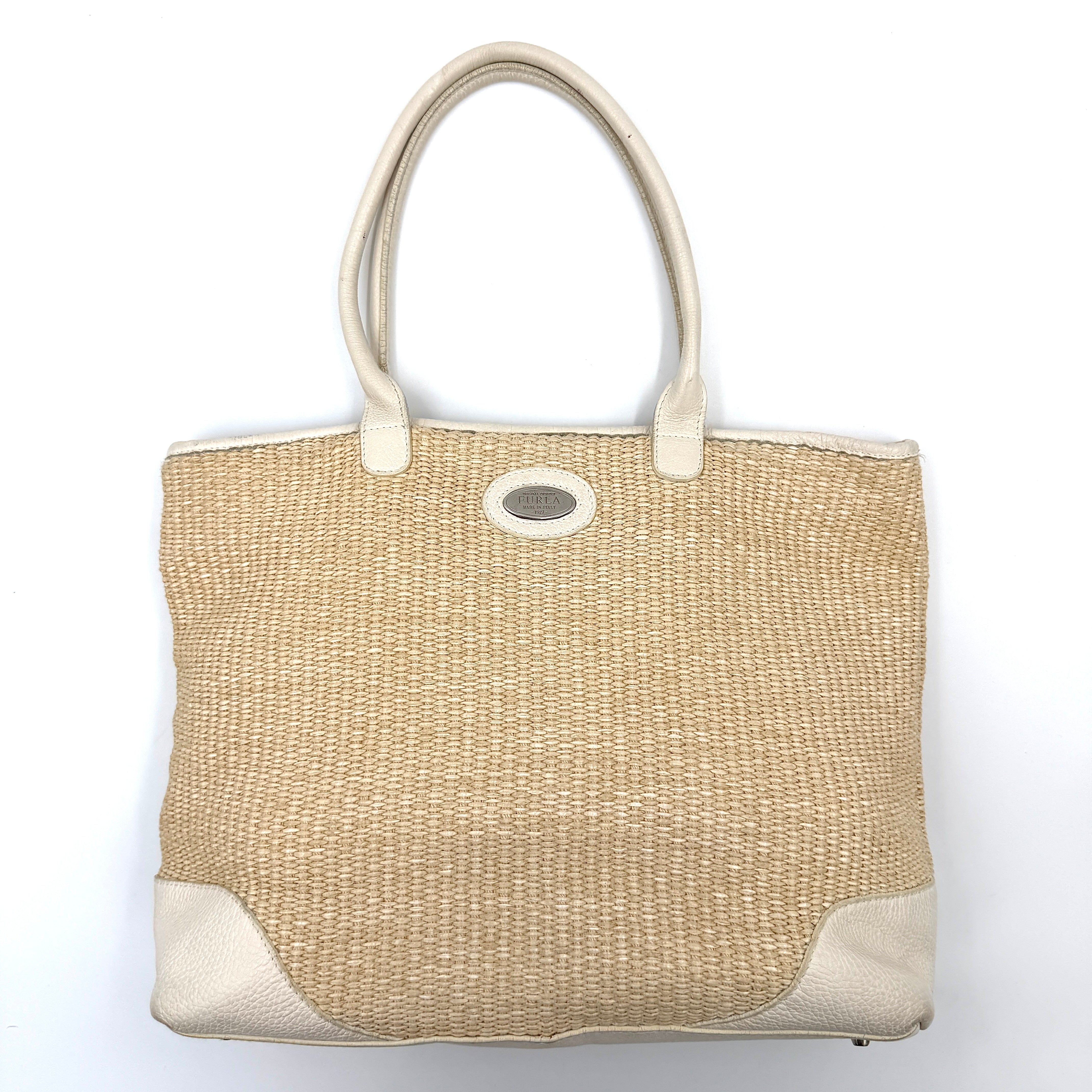 Furla beige woven straw tote bag with off-white leather handles and corners, featuring a silver oval logo plaque.