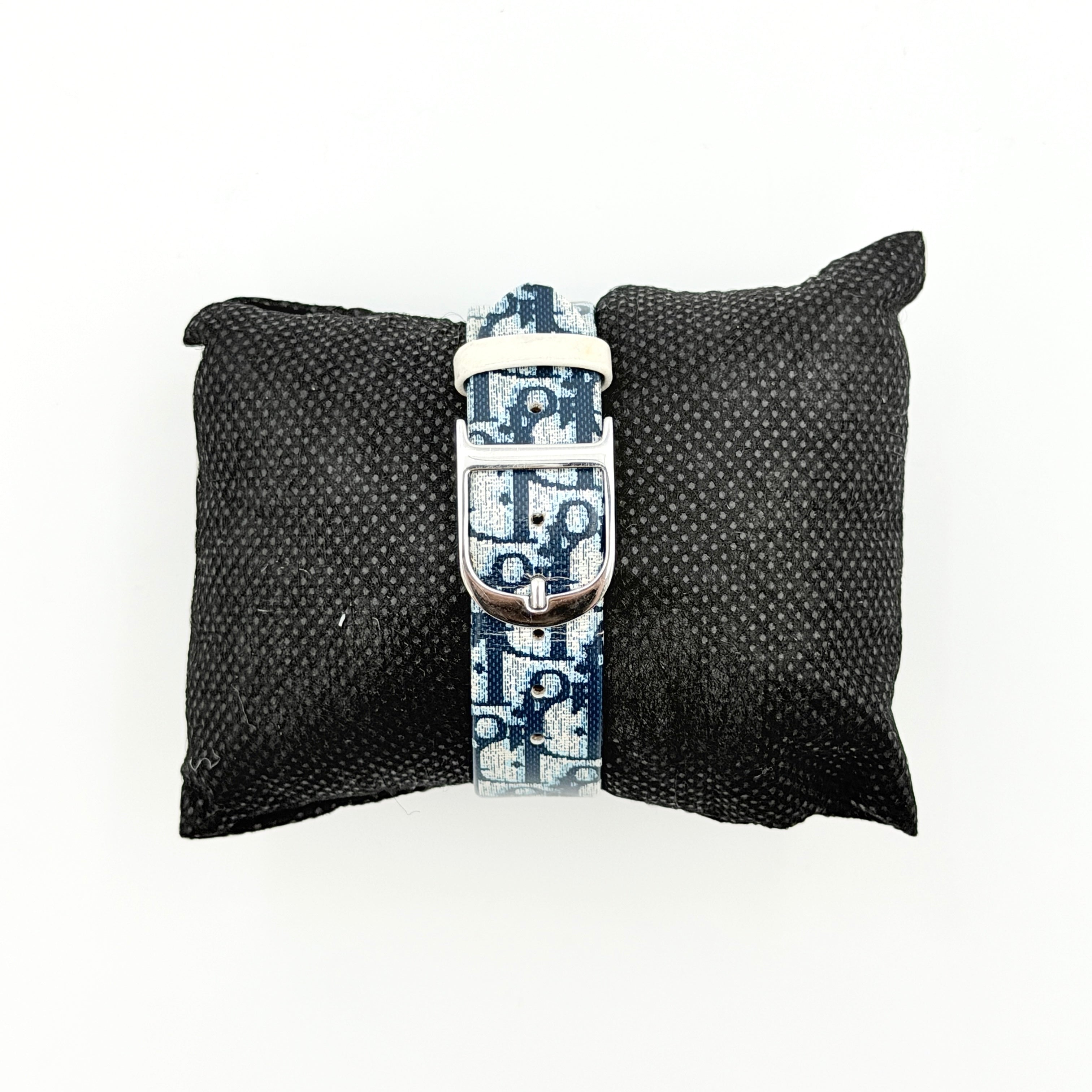 Dior Trotter Malice Watch with blue monogram strap and extra interchangeable yellow and black straps displayed.