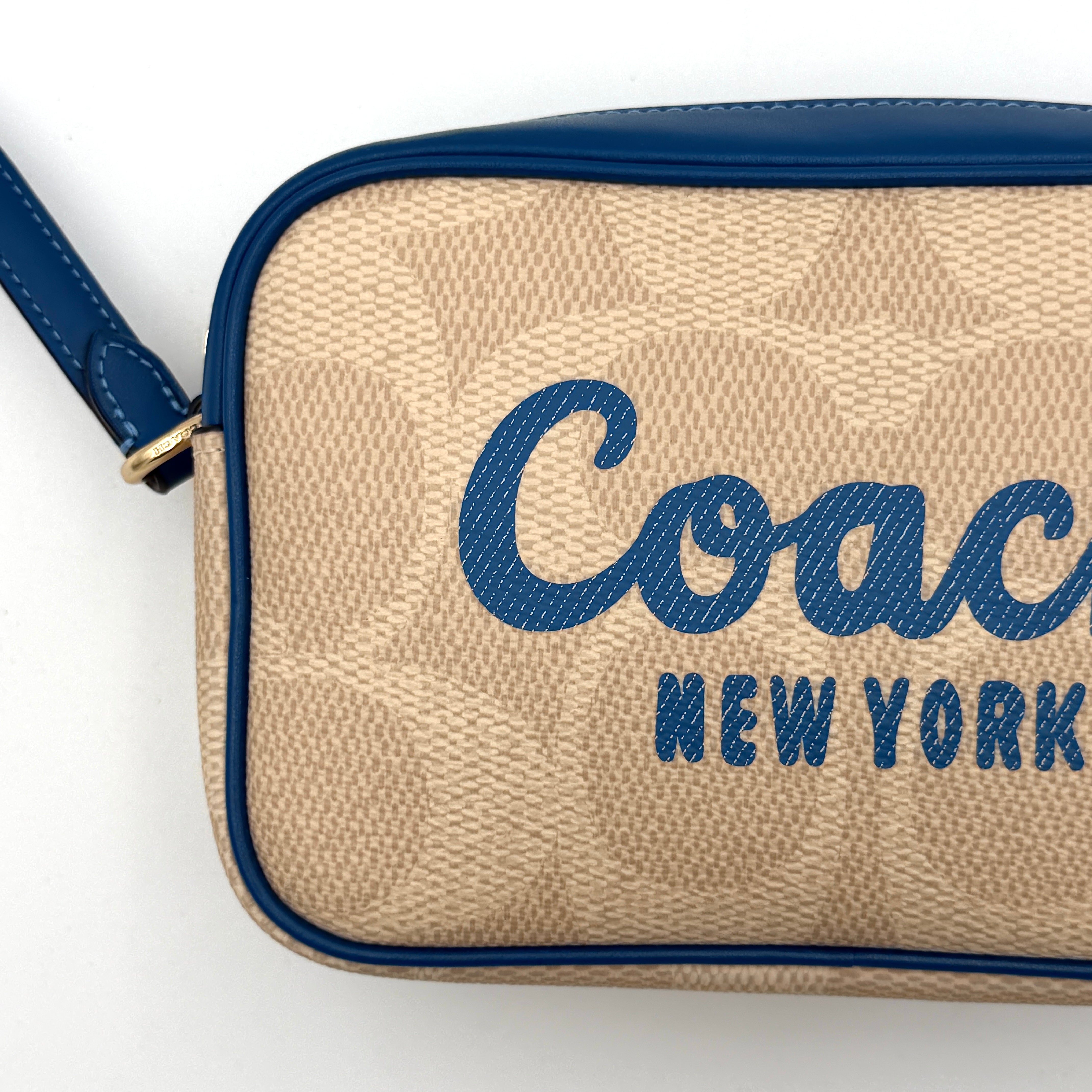 Coach Signature Jamie Camera Crossbody Bag in beige canvas with bold blue logo, cobalt trim, and adjustable blue leather strap.
