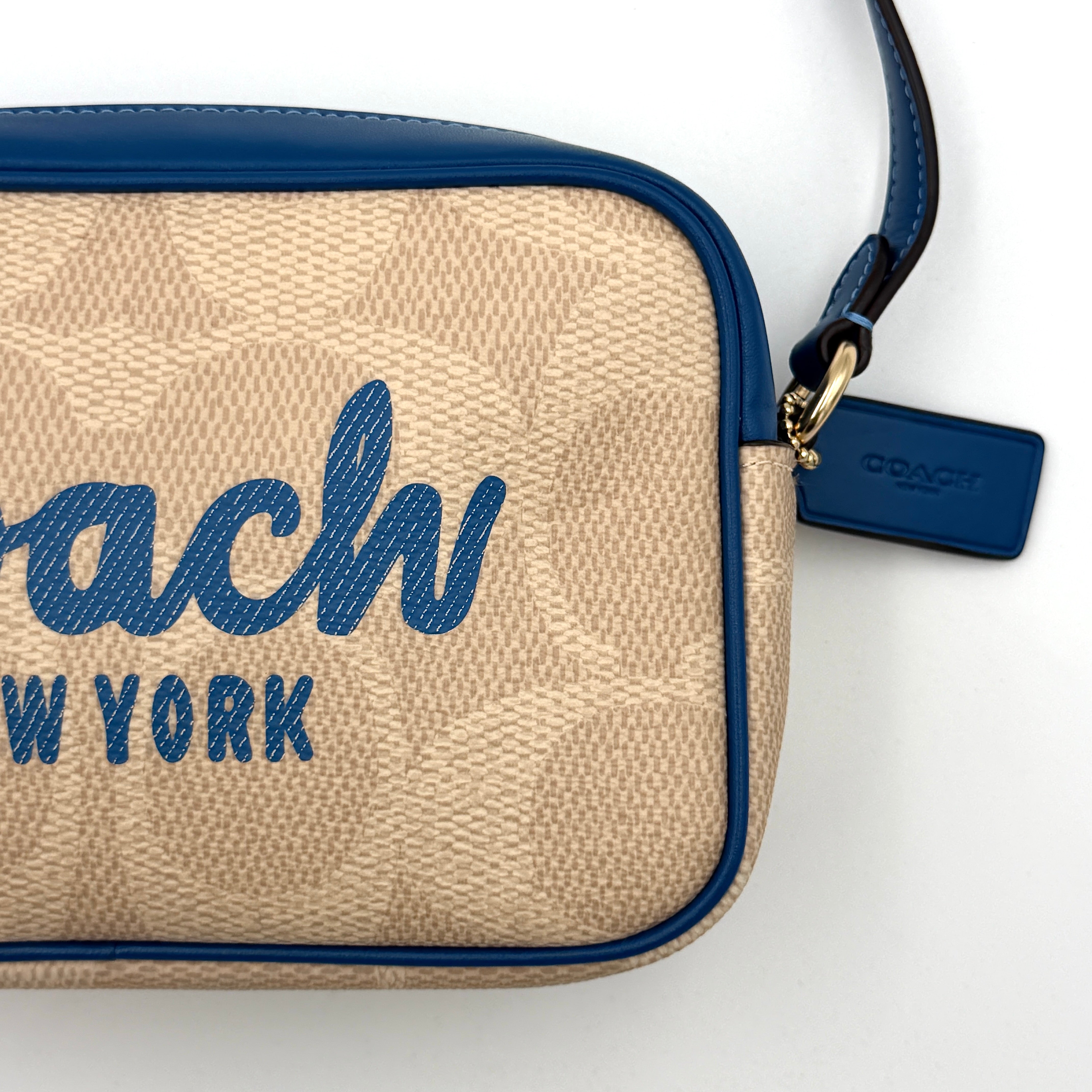 Coach Signature Jamie Camera Crossbody Bag in beige canvas with bold blue logo, cobalt trim, and adjustable blue leather strap.