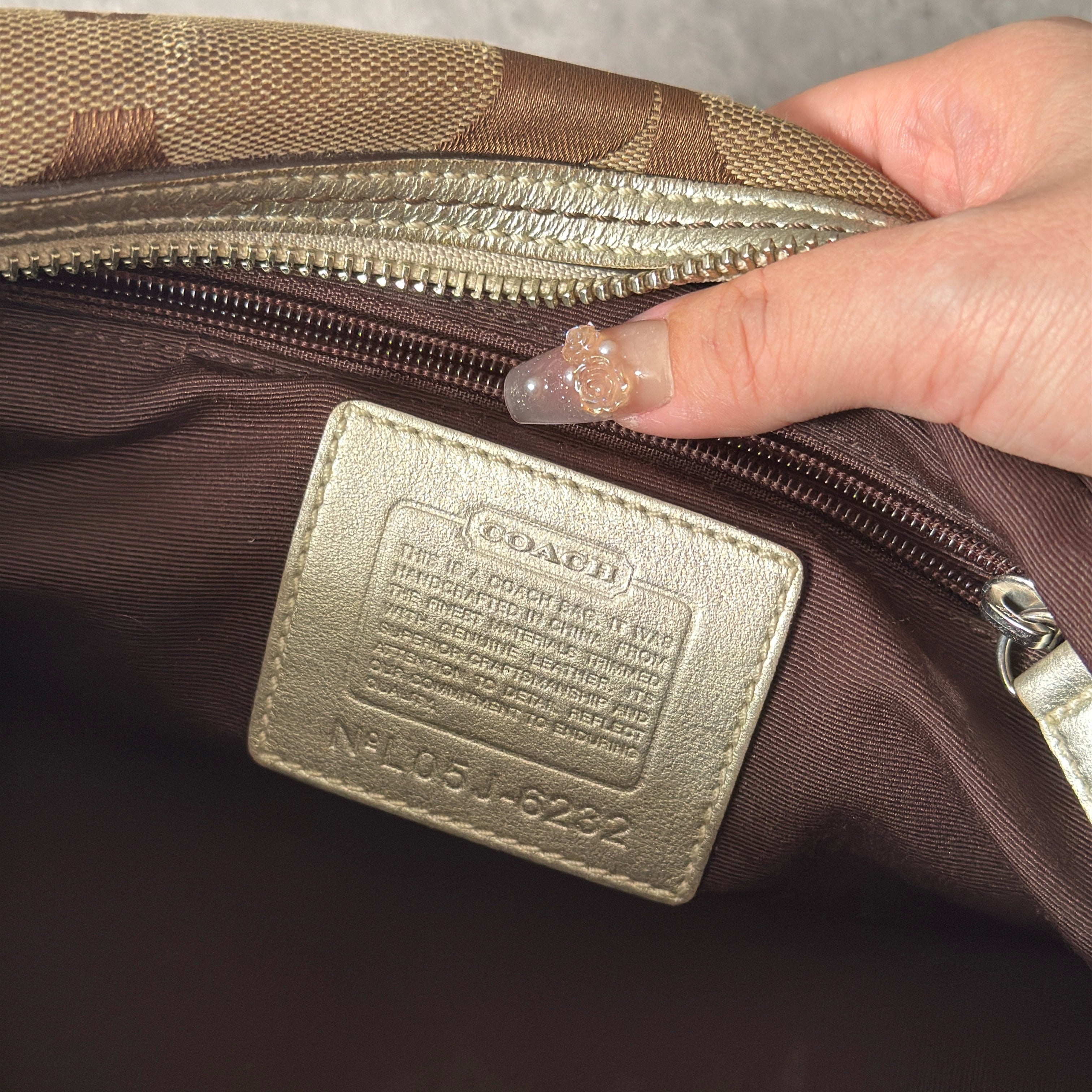 Coach 2Way Poppy Signature Bag in beige monogram canvas with silver leather trim, featuring double handles, turn-lock front pockets, and a spacious interior.