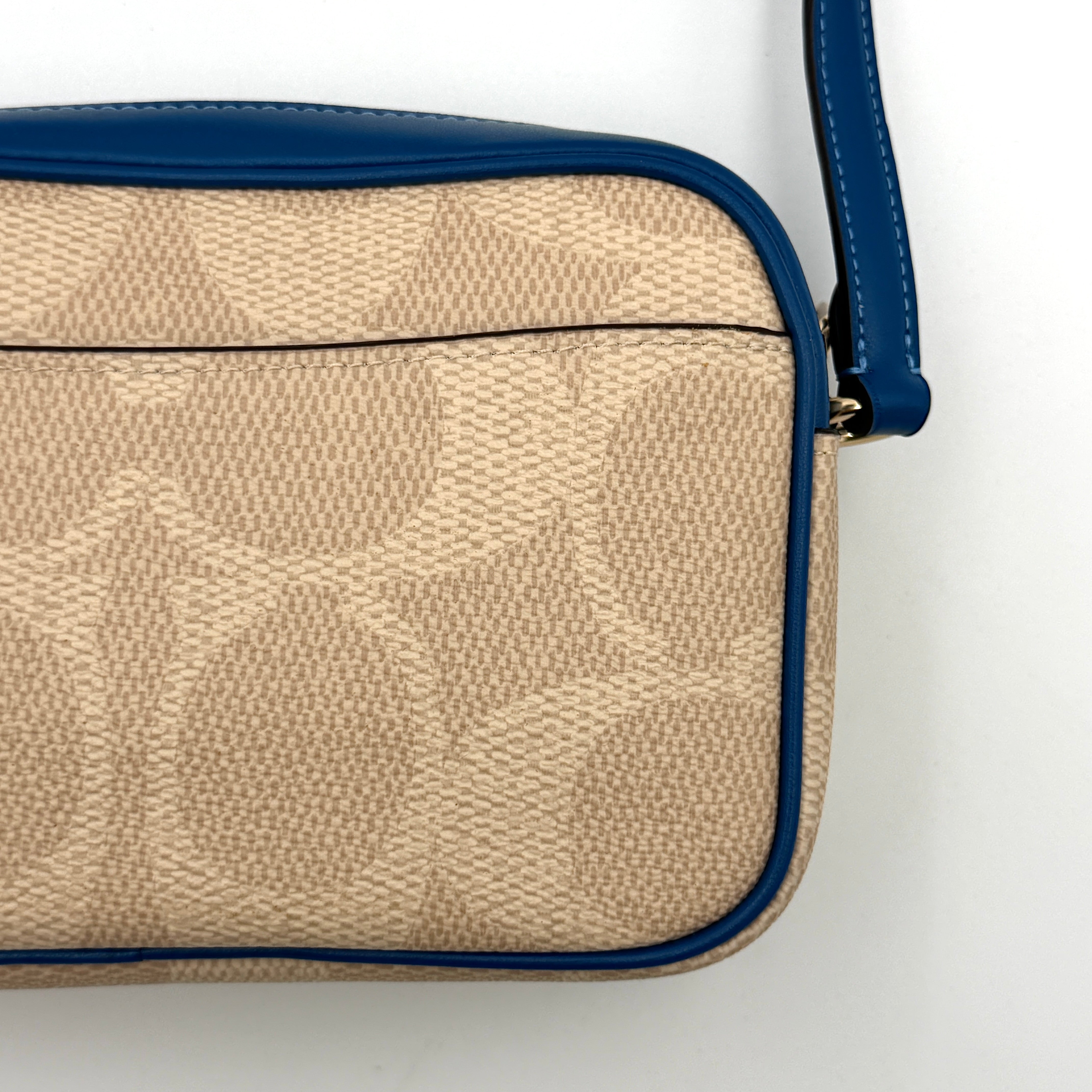 Coach Signature Jamie Camera Crossbody Bag in beige canvas with bold blue logo, cobalt trim, and adjustable blue leather strap.