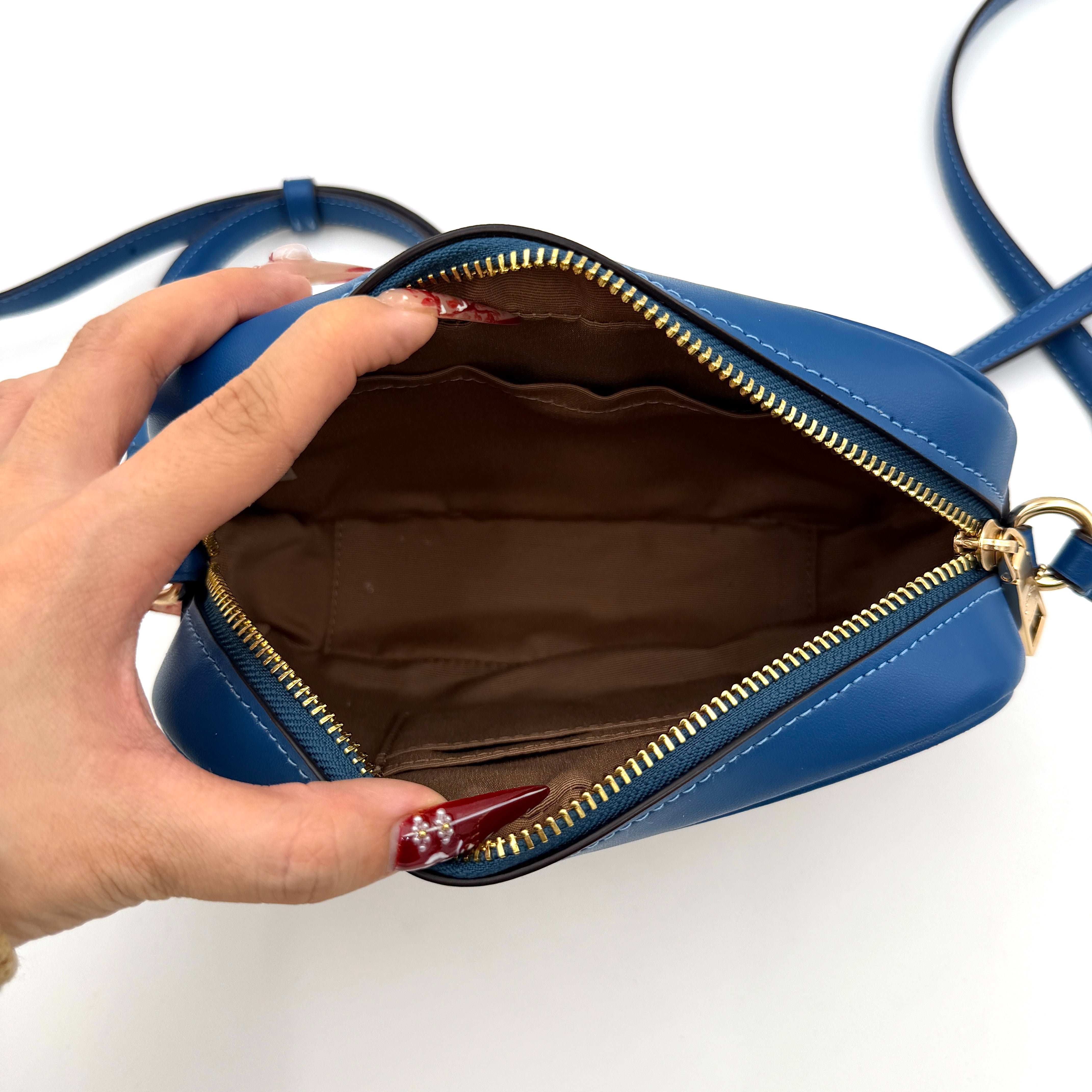 Coach Signature Jamie Camera Crossbody Bag in beige canvas with bold blue logo, cobalt trim, and adjustable blue leather strap.