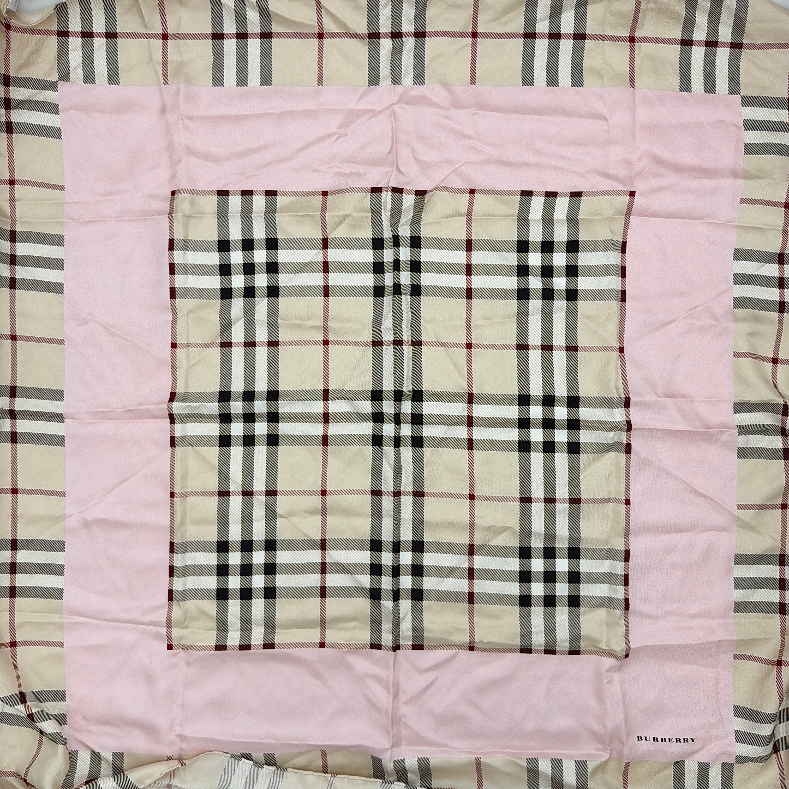 Burberry silk scarf in pale pink and beige, showcasing the iconic Nova Check pattern with burgundy highlights and a subtle brand signature.
