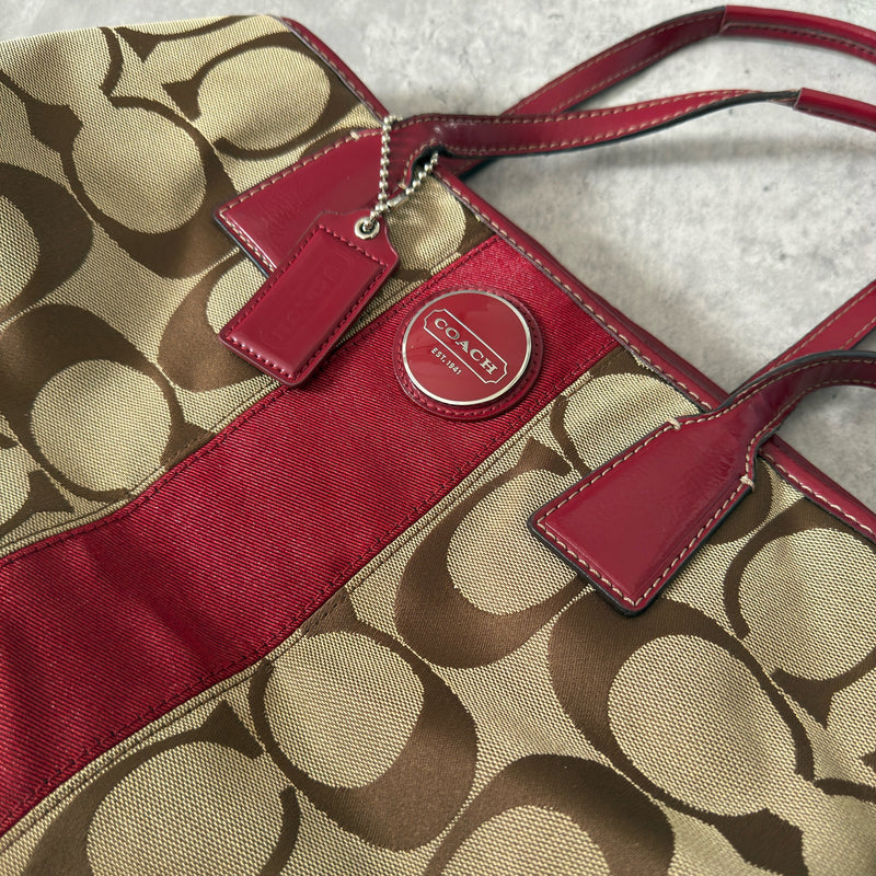 Coach Framed Kiss Lock Carryall Satchel in tan and red stripe with signature monogram canvas, silver-tone hardware, and spacious red fabric-lined interior.