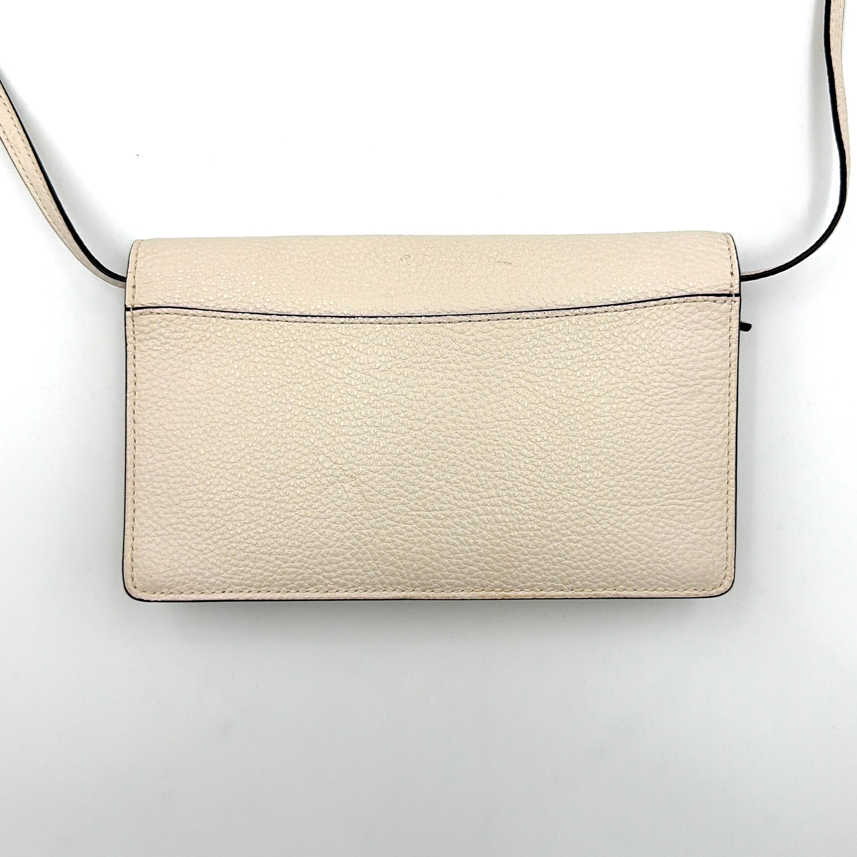 Coach x Disney Dumbo cream foldover crossbody bag with Dumbo illustration and slender strap, displayed against white background.