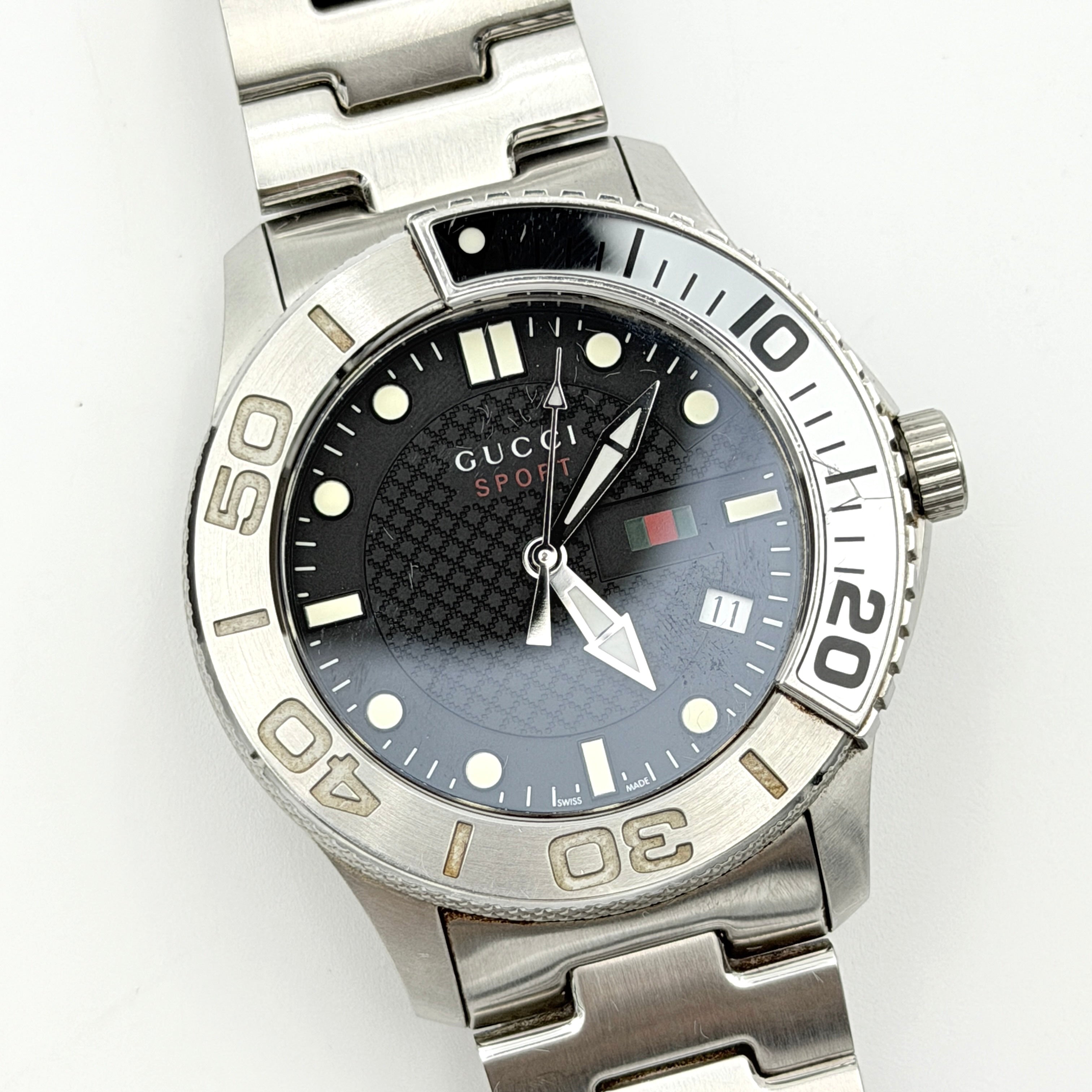 Gucci G-Timeless Sport Watch in silver with black dial, presented in its original box with booklet and extra links.