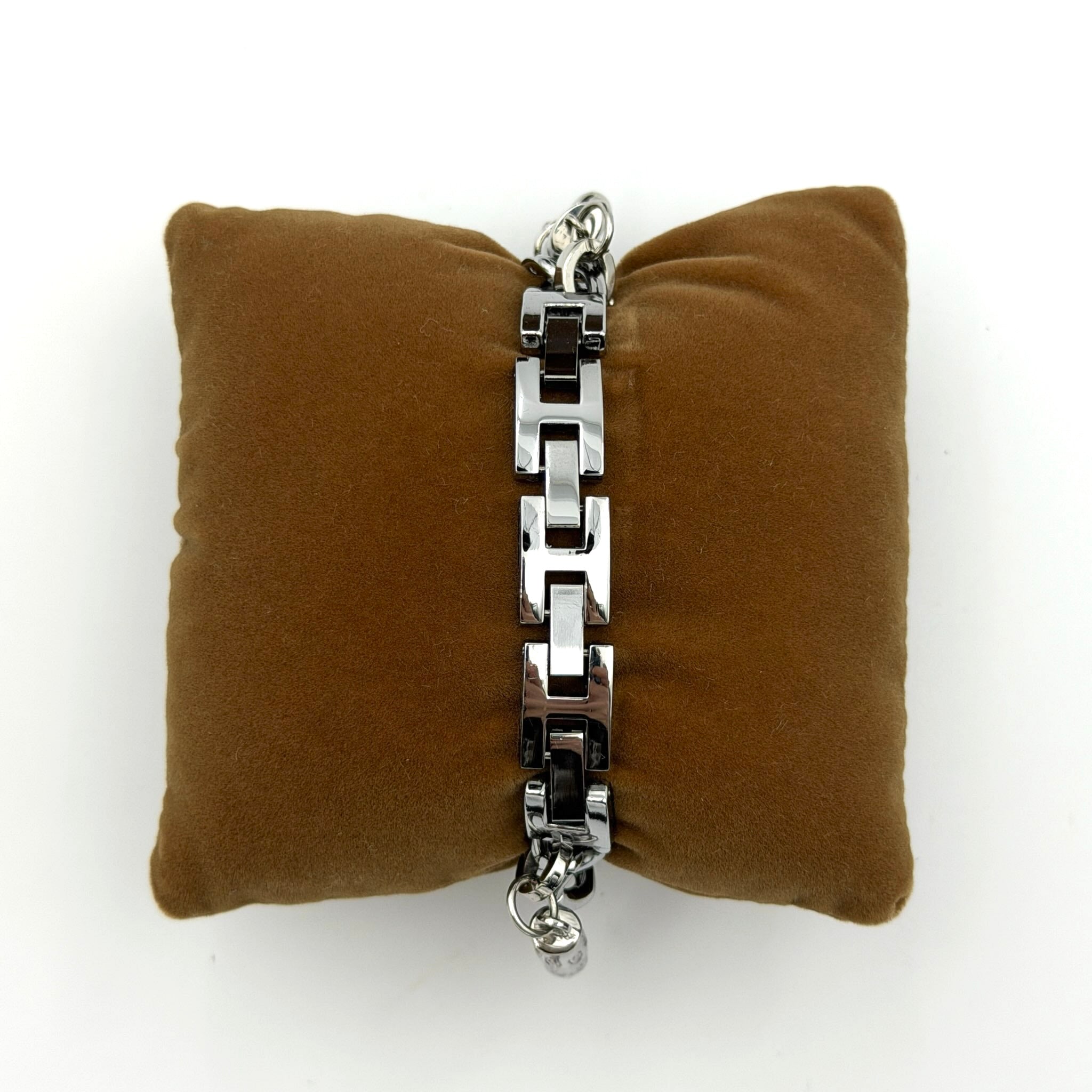 Gucci 107 G Charm Bracelet Watch with silver chunky chain and pink dial, styled on a brown cushion with original Gucci box.