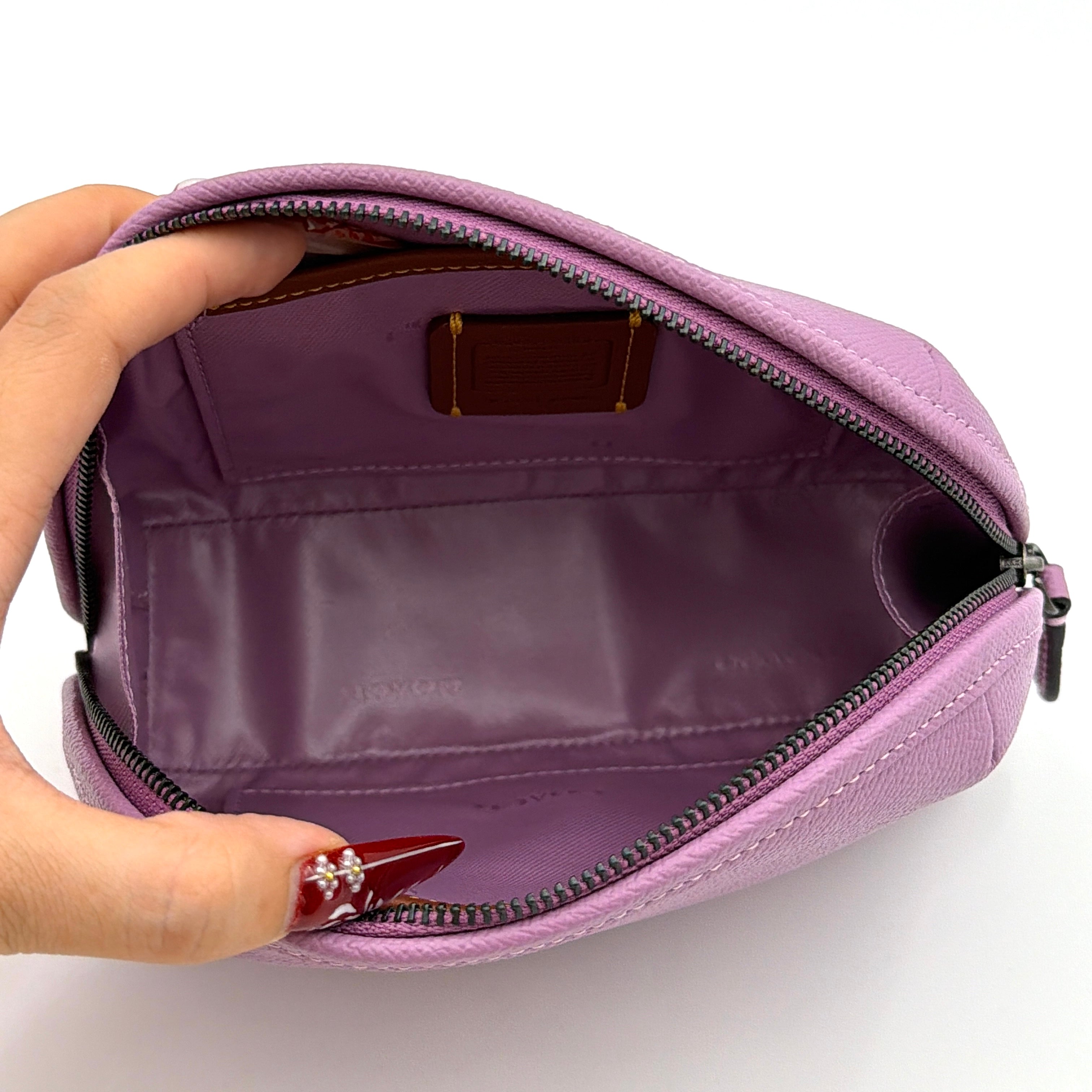 Coach Julienne Cosmetic Case 17 in purple grained leather with black hardware, photographed on a plain background.