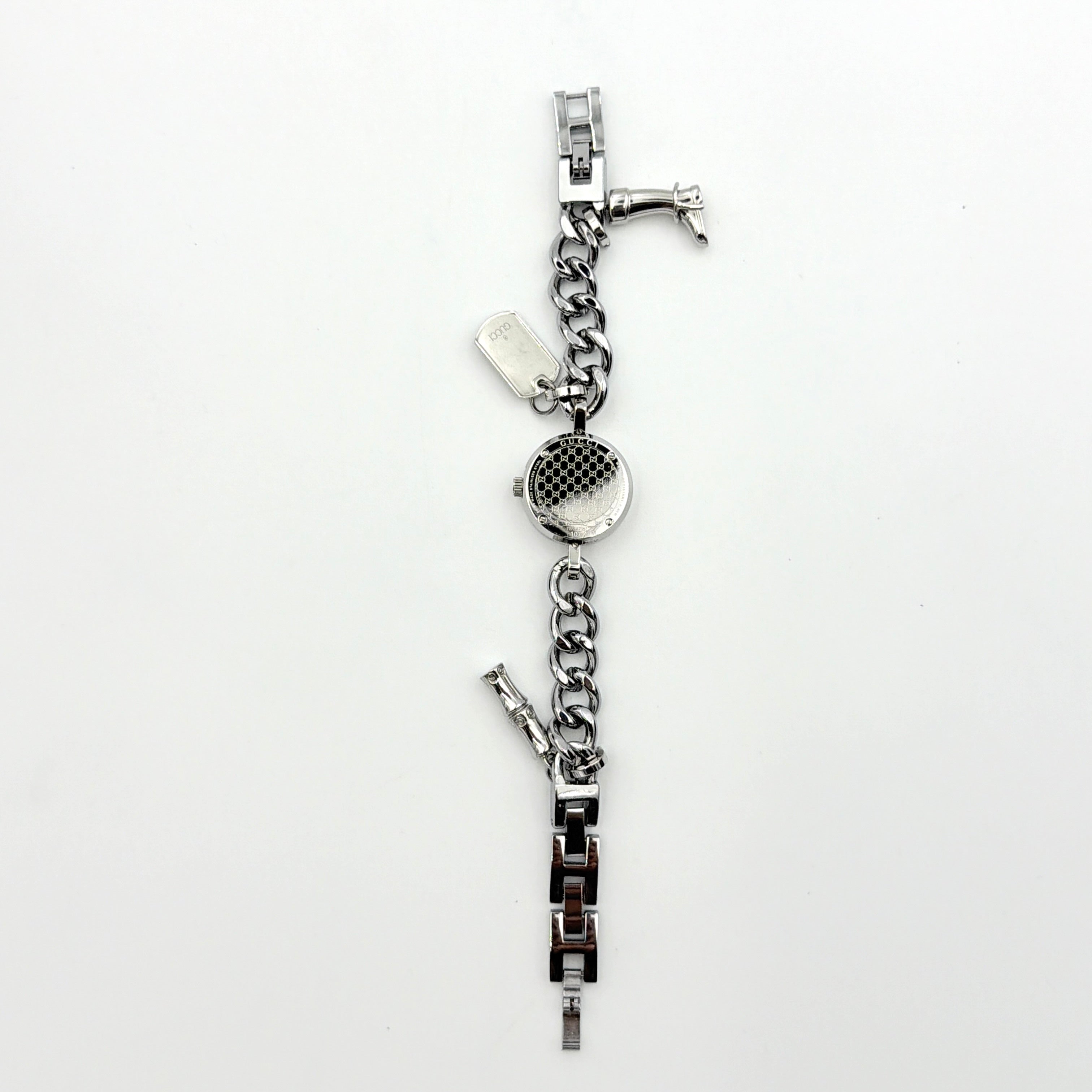 Gucci 107 G Charm Bracelet Watch with silver chunky chain and pink dial, styled on a brown cushion with original Gucci box.