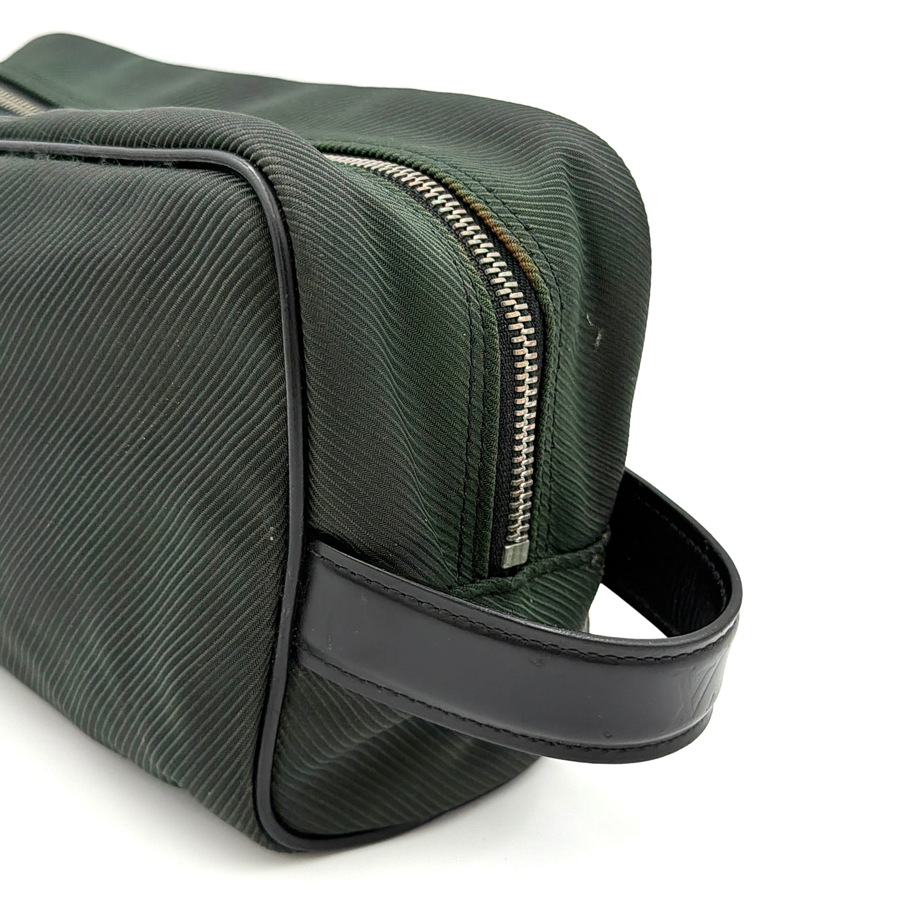 Louis Vuitton Taiga Parana Clutch Bag in deep green Taiga leather with black leather handle and silver-tone zipper, shown from the front.