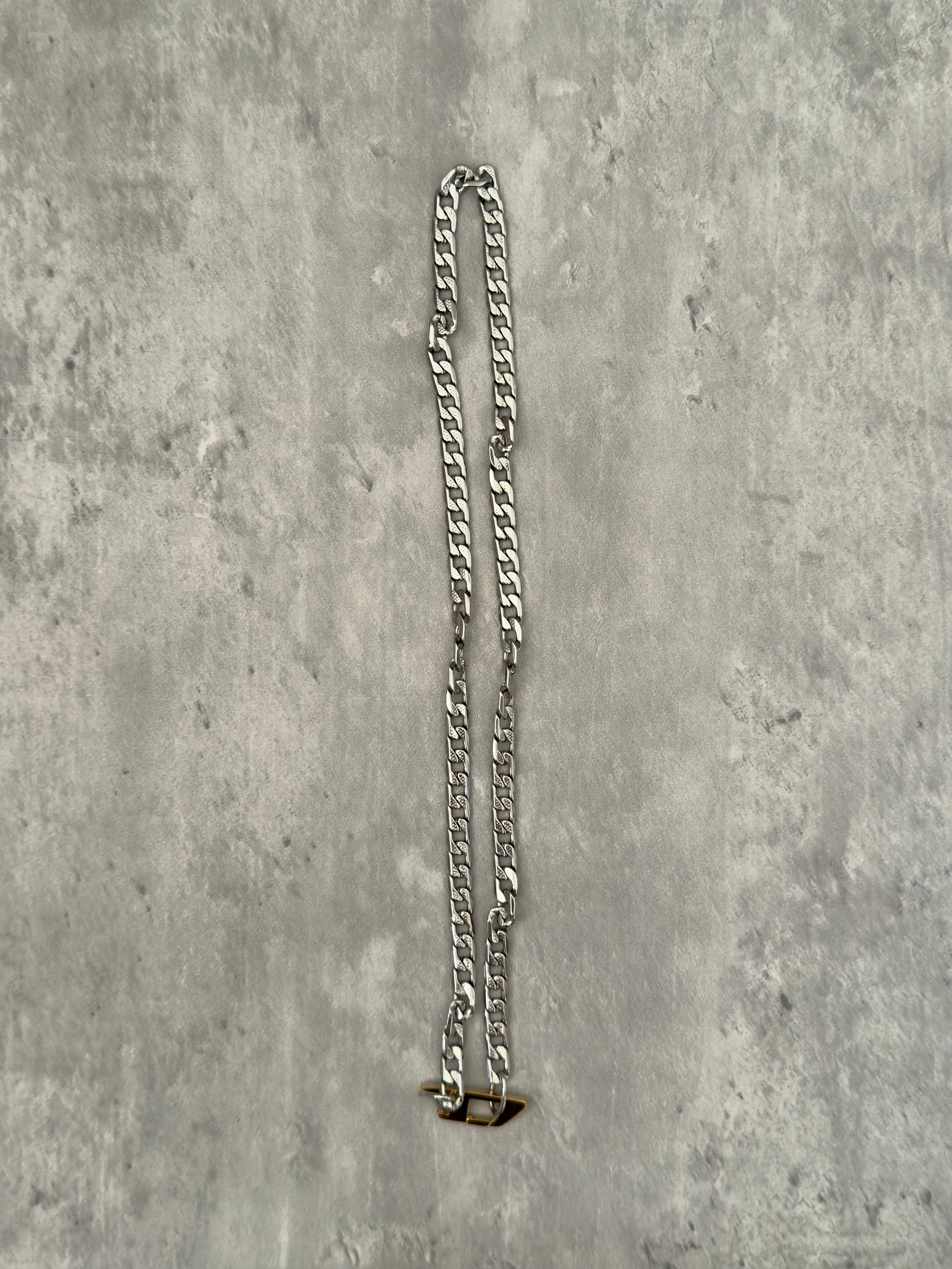Diesel Signature Gold D-Logo Stainless Steel Necklace, featuring a silver-tone chunky chain with a gold-tone Diesel "D" logo pendant.