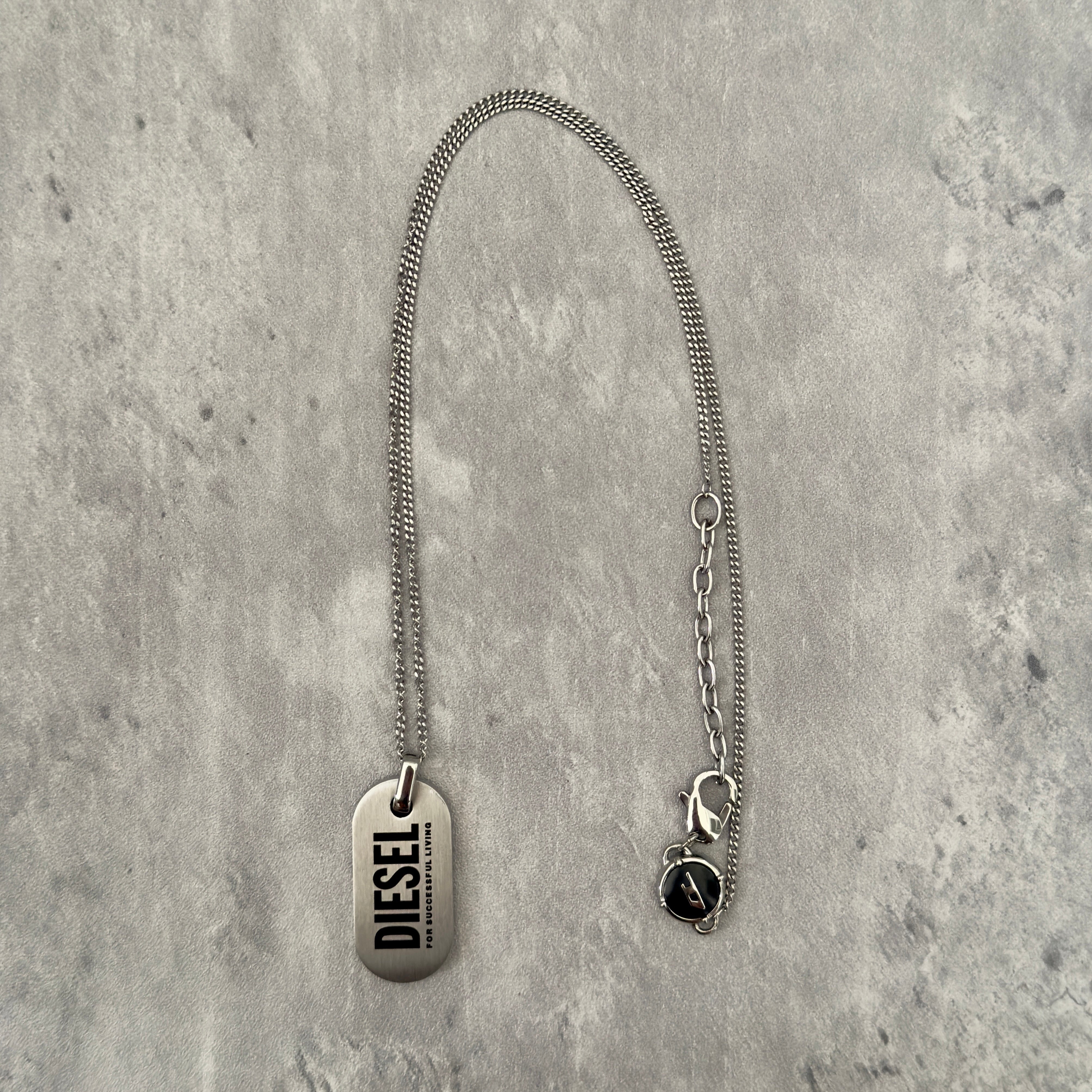 Diesel Signature 'For Successful Living' Dog Tag Necklace in stainless steel, featuring a brushed metal pendant and fine box chain.