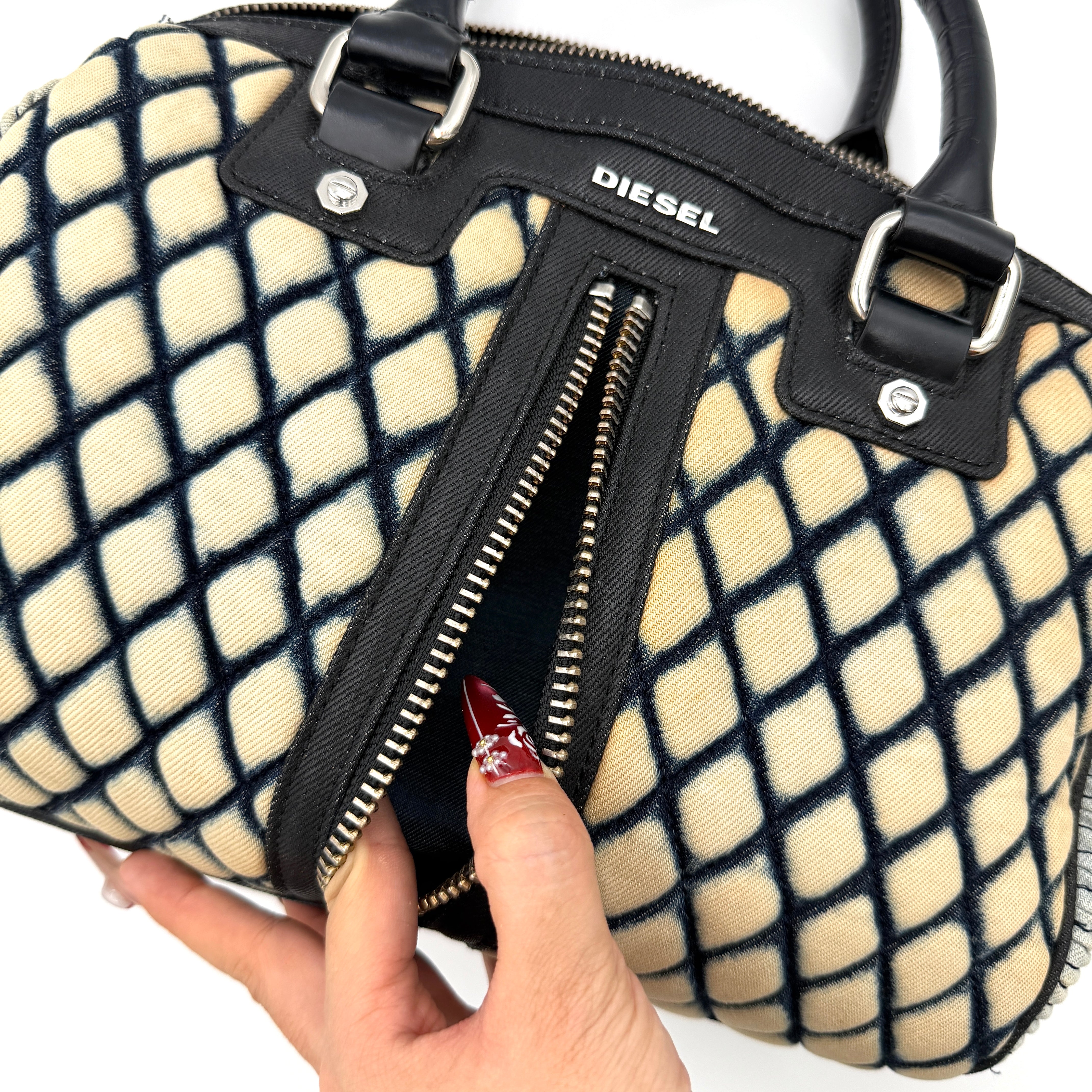 Diesel 2Way Boston Handbag in cream canvas with black velvet-effect lattice, dual leather handles, and detachable strap displayed in front.