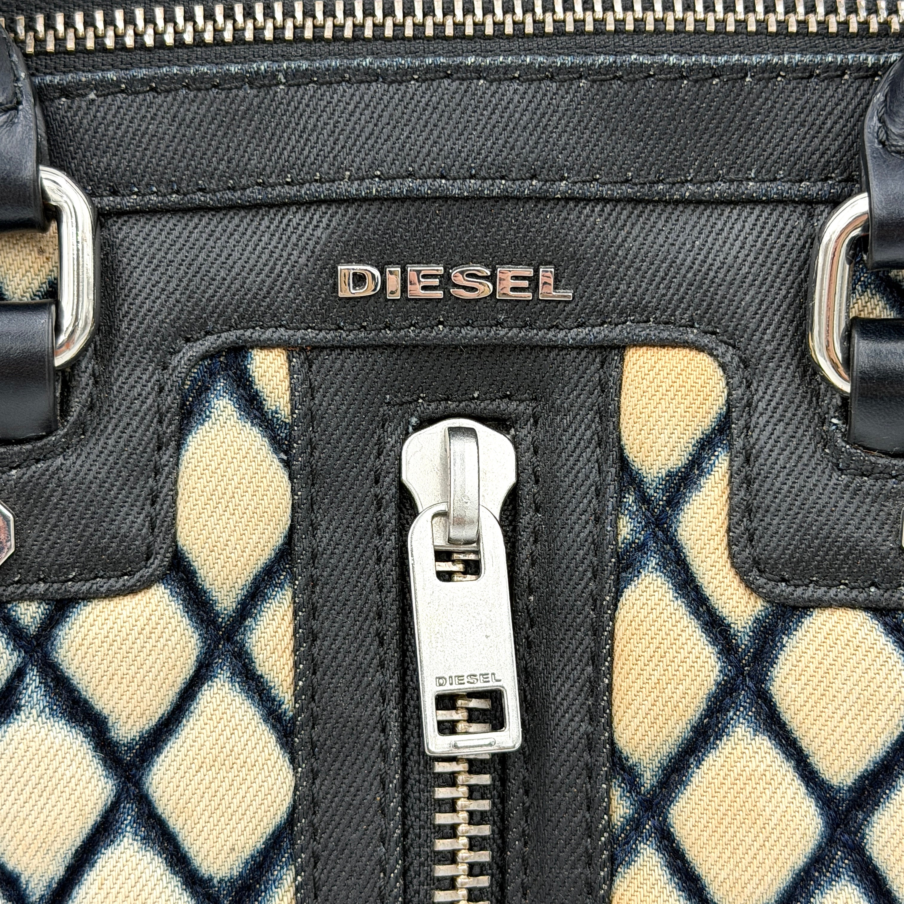 Diesel 2Way Boston Handbag in cream canvas with black velvet-effect lattice, dual leather handles, and detachable strap displayed in front.