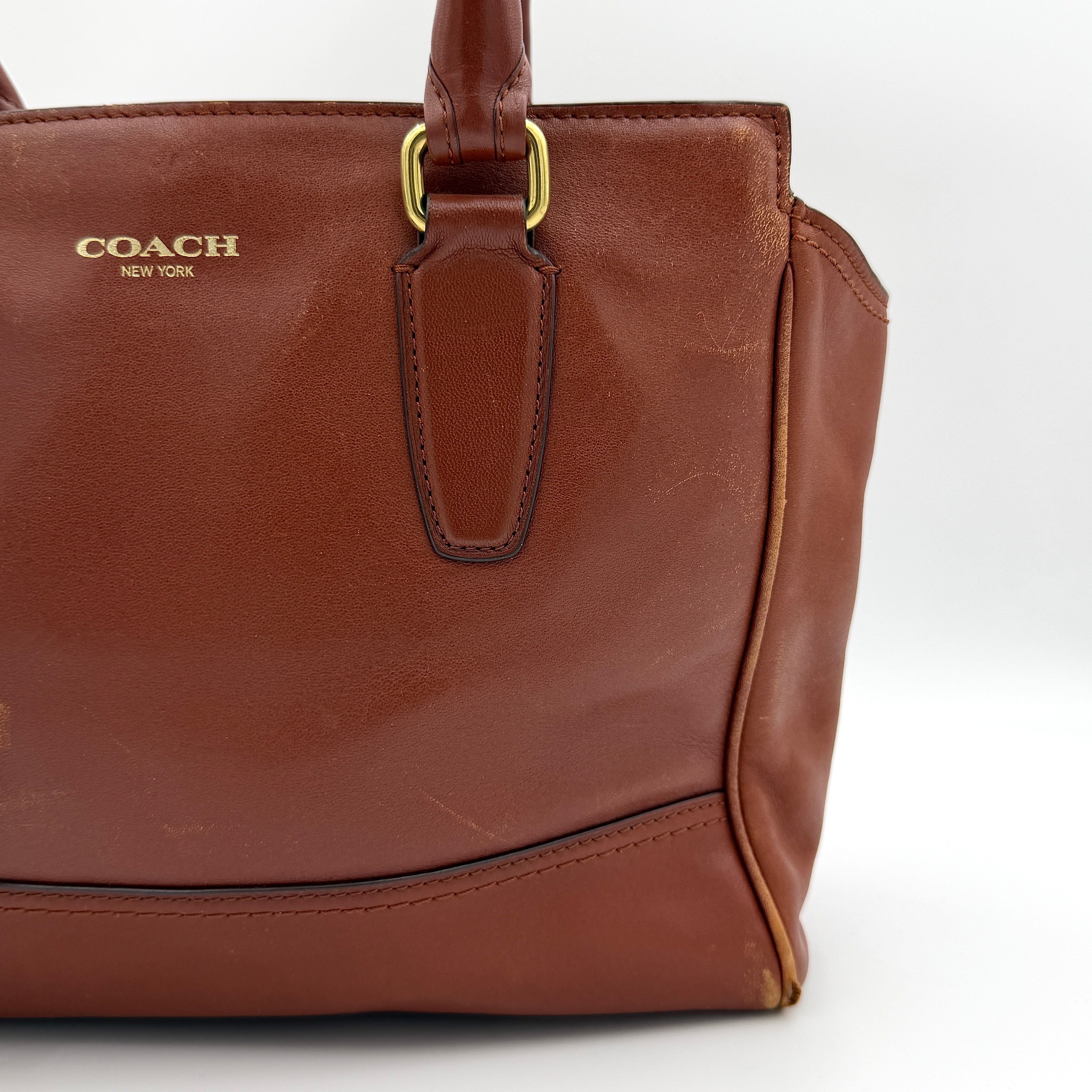 Coach Legacy Candace Carryall in smooth brown leather with gold hardware, rolled handles, and signature tassel accents.