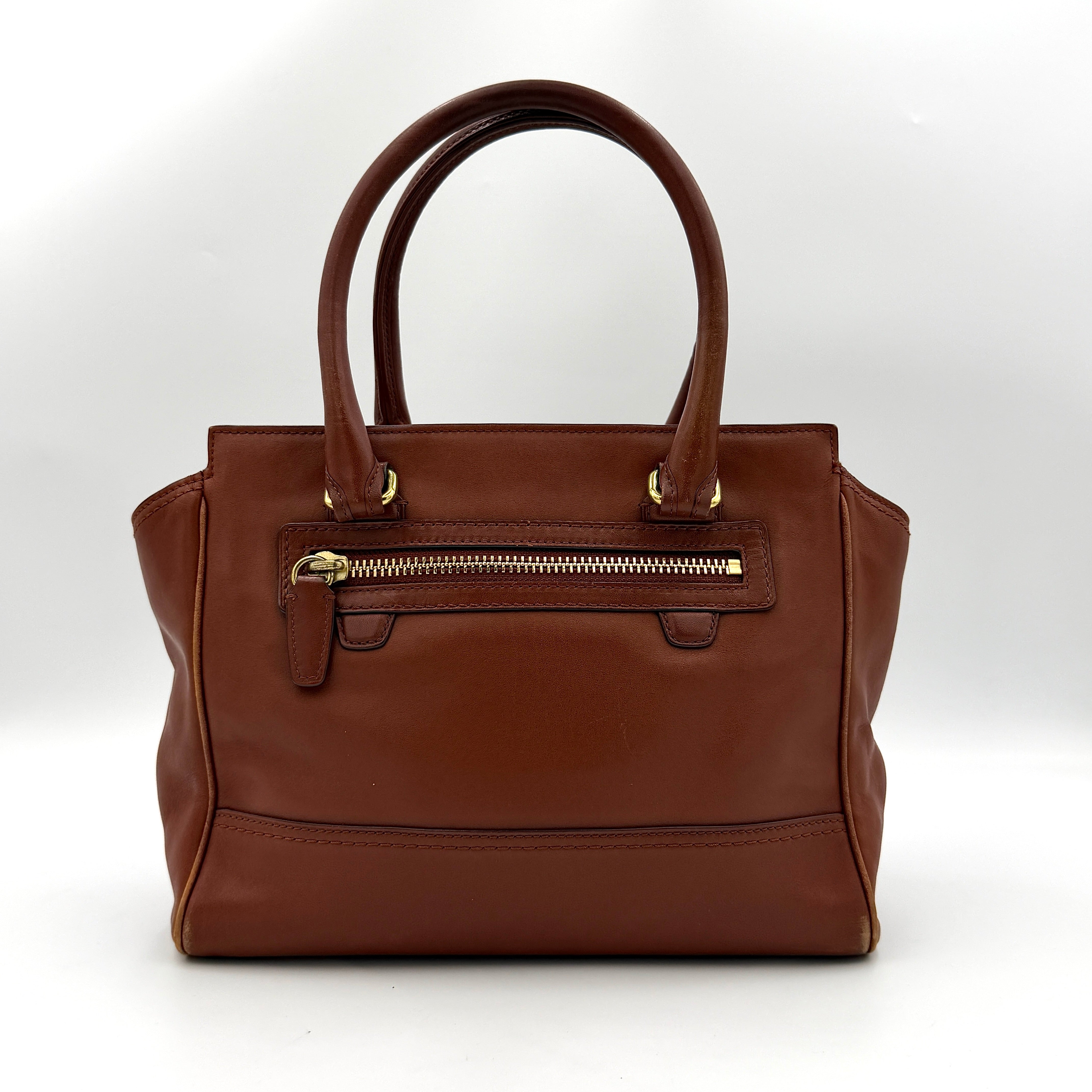 Coach Legacy Candace Carryall in smooth brown leather with gold hardware, rolled handles, and signature tassel accents.
