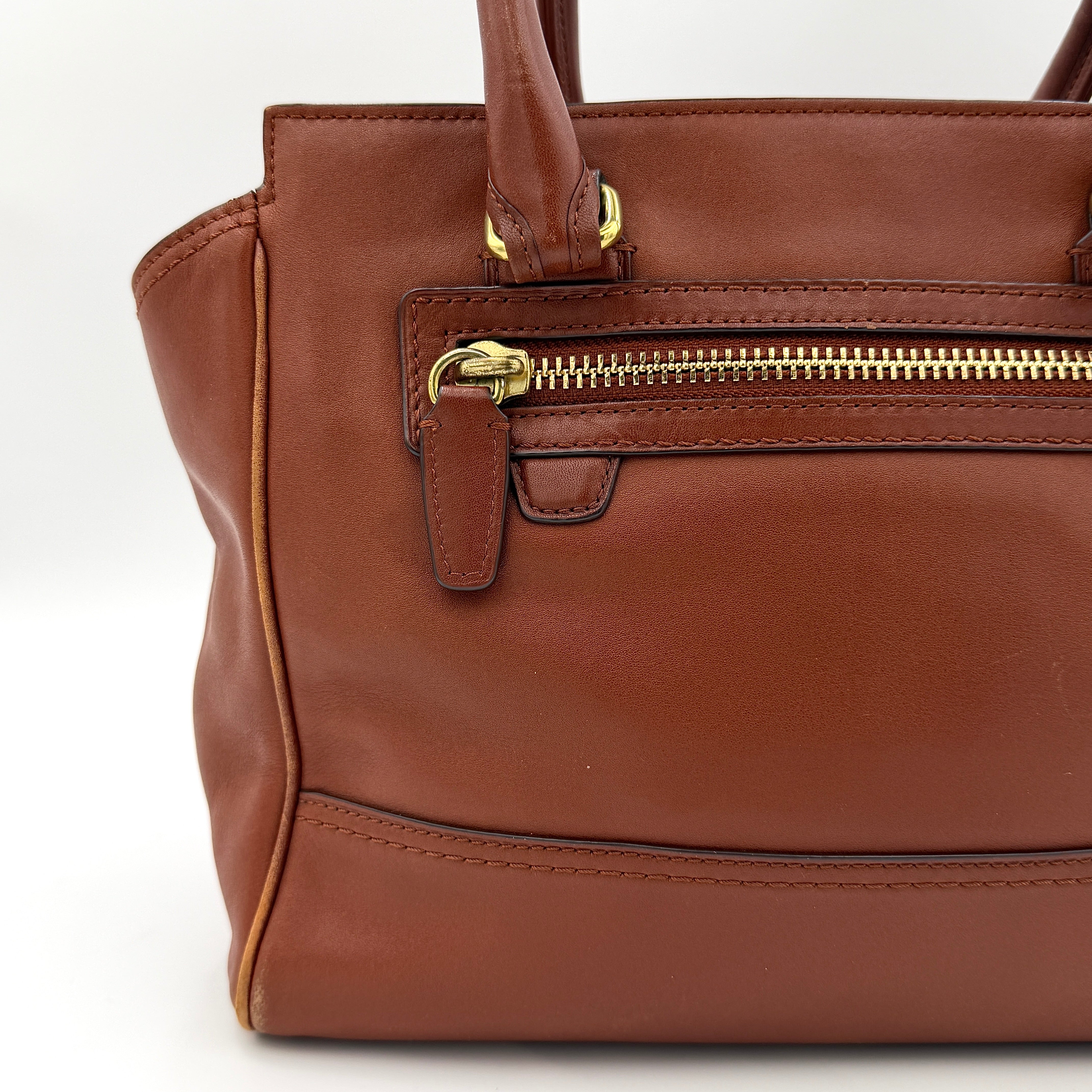 Coach Legacy Candace Carryall in smooth brown leather with gold hardware, rolled handles, and signature tassel accents.