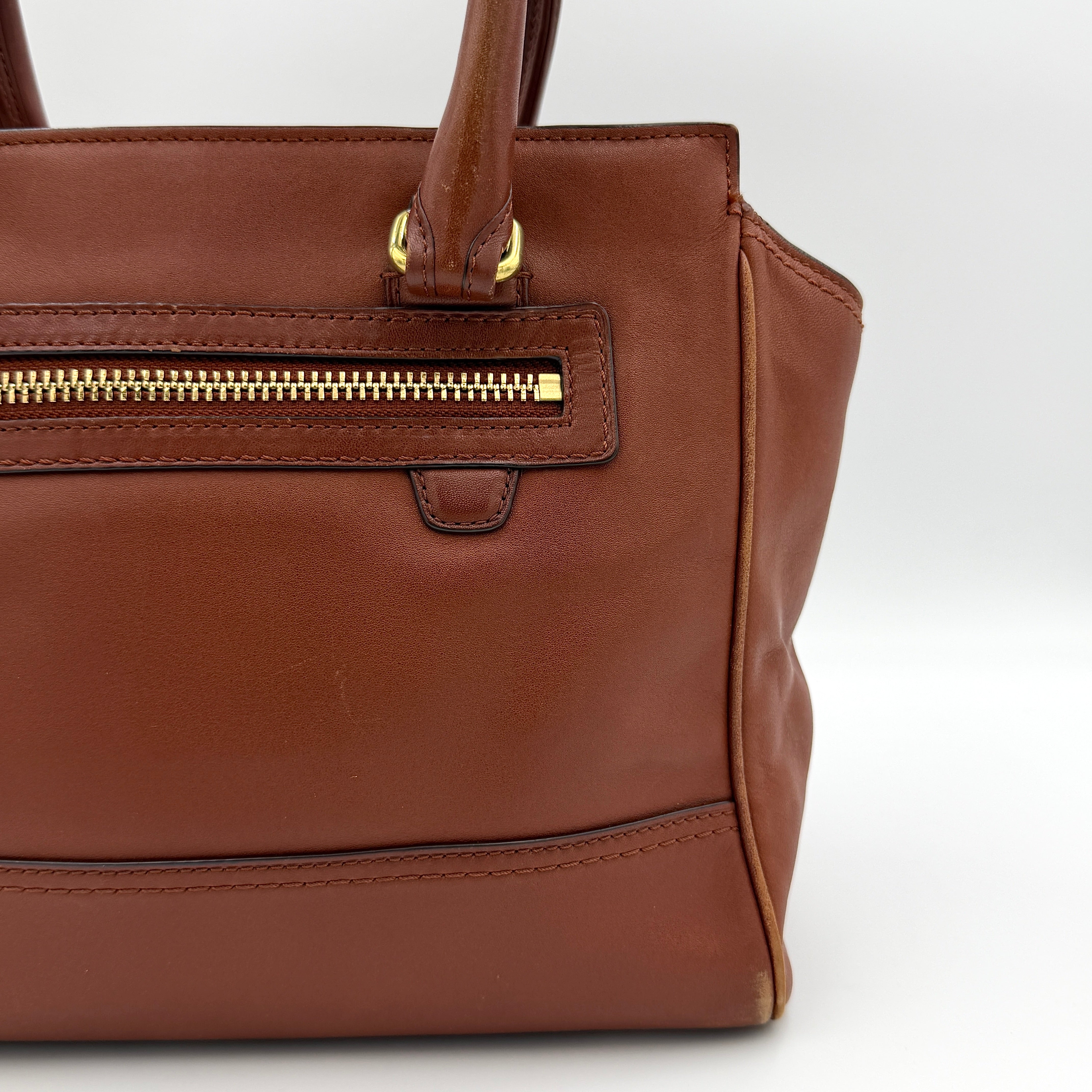 Coach Legacy Candace Carryall in smooth brown leather with gold hardware, rolled handles, and signature tassel accents.