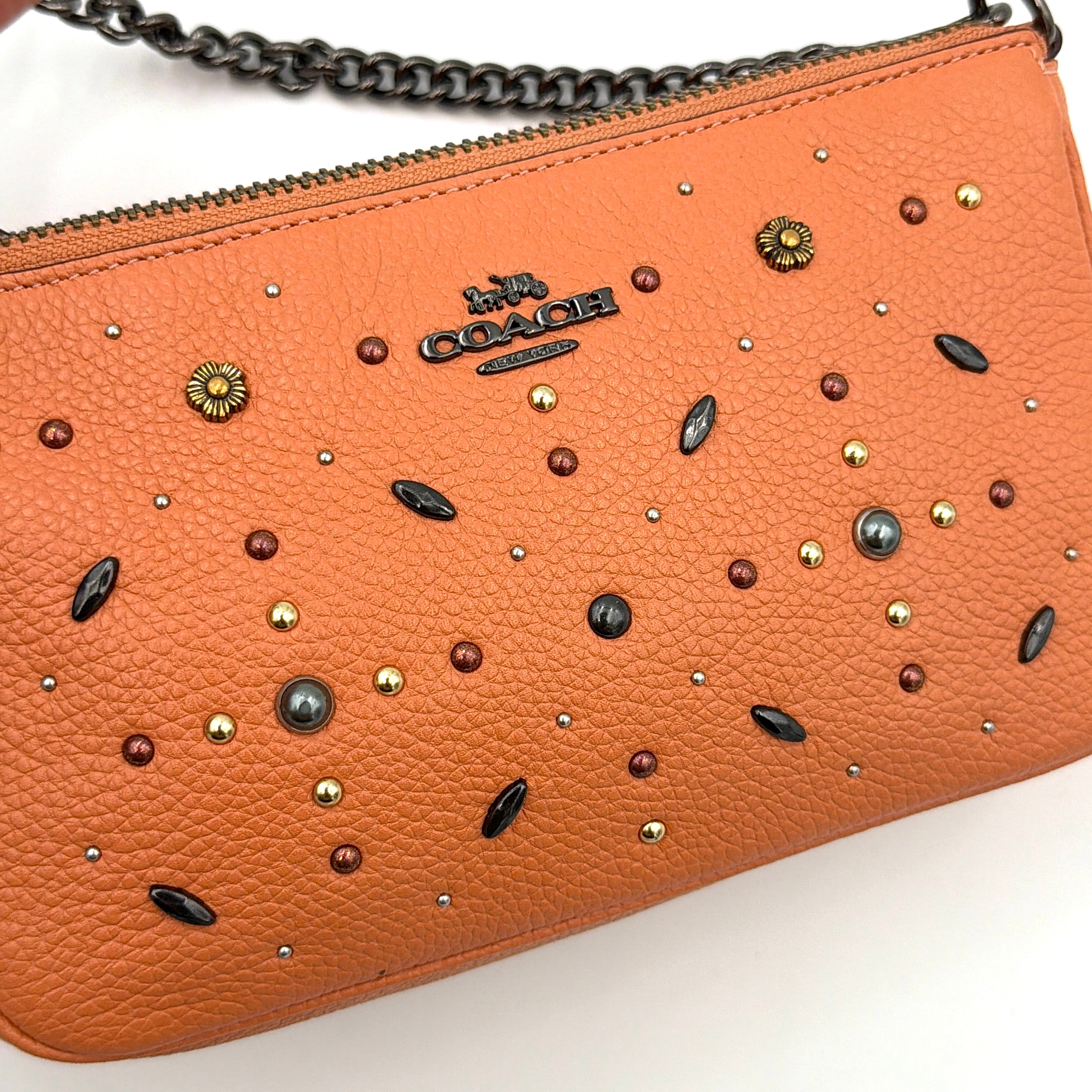 Coach Nolita 19 Prairie Rivets Shoulder Bag in bold orange pebbled leather with mixed metal rivet embellishments and chunky chain strap.