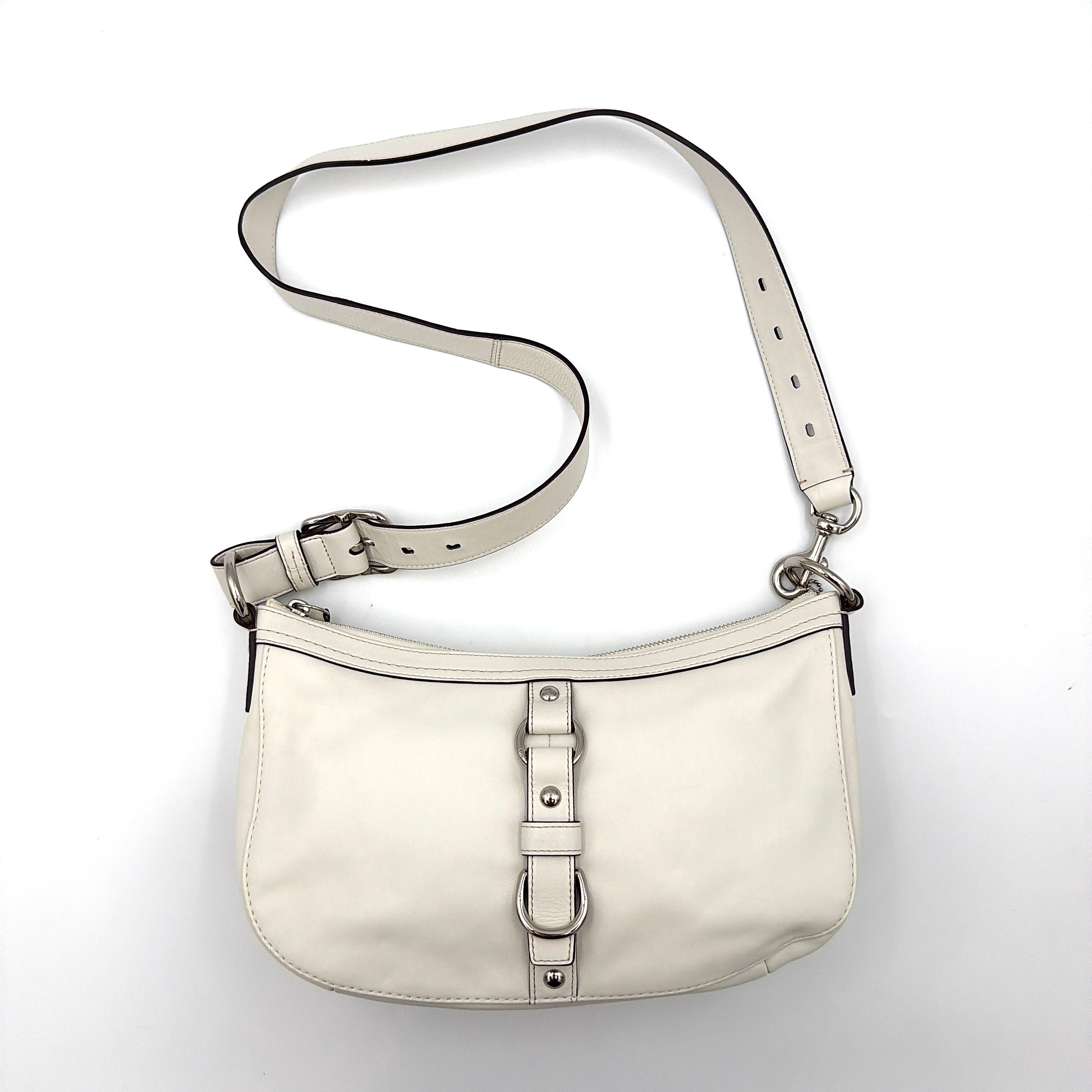 Coach 2Way Buckle Shoulder Bag in smooth ivory leather with silver-tone hardware and an adjustable strap, styled against a white background.