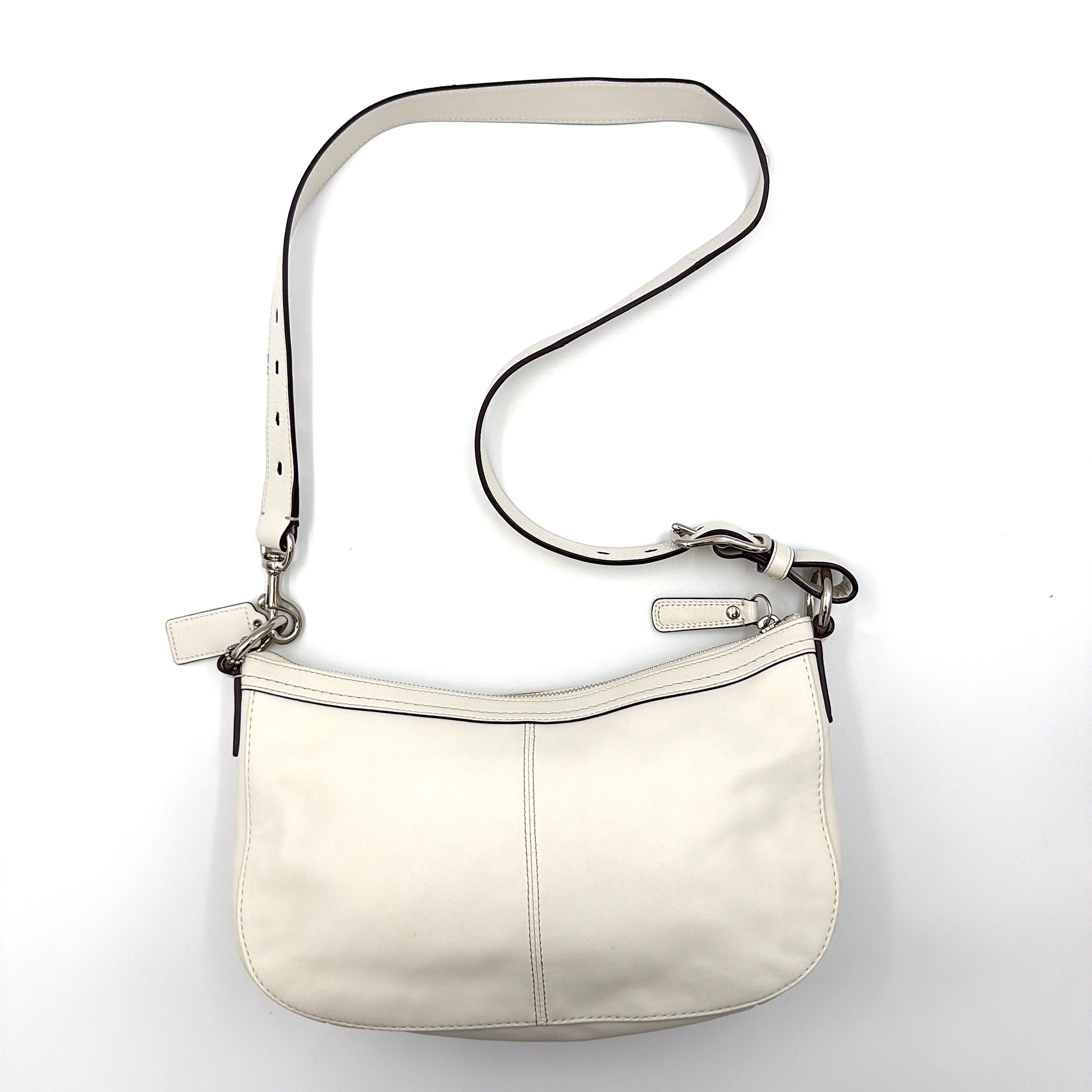 Coach 2Way Buckle Shoulder Bag in smooth ivory leather with silver-tone hardware and an adjustable strap, styled against a white background.