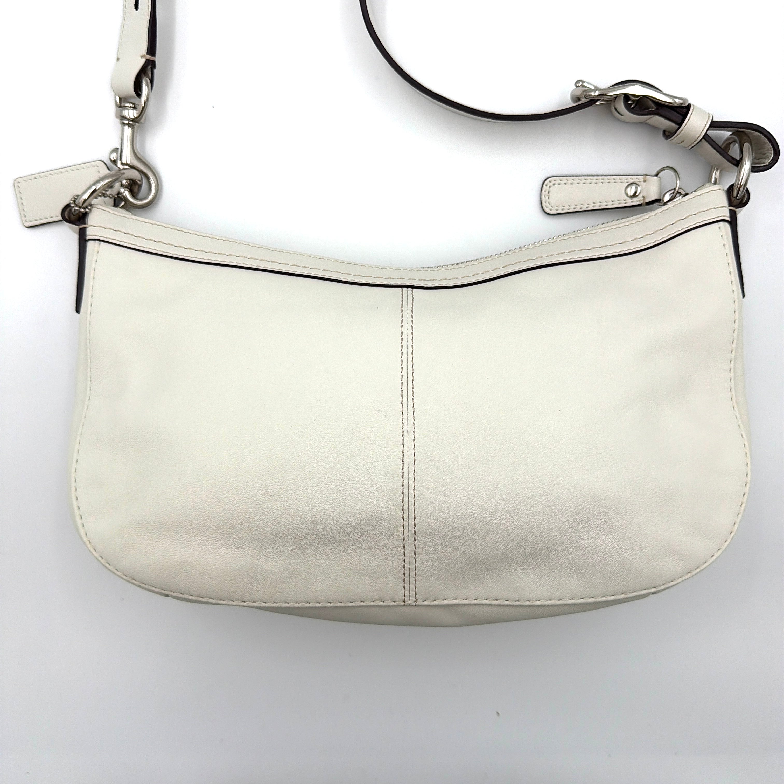 Coach 2Way Buckle Shoulder Bag in smooth ivory leather with silver-tone hardware and an adjustable strap, styled against a white background.