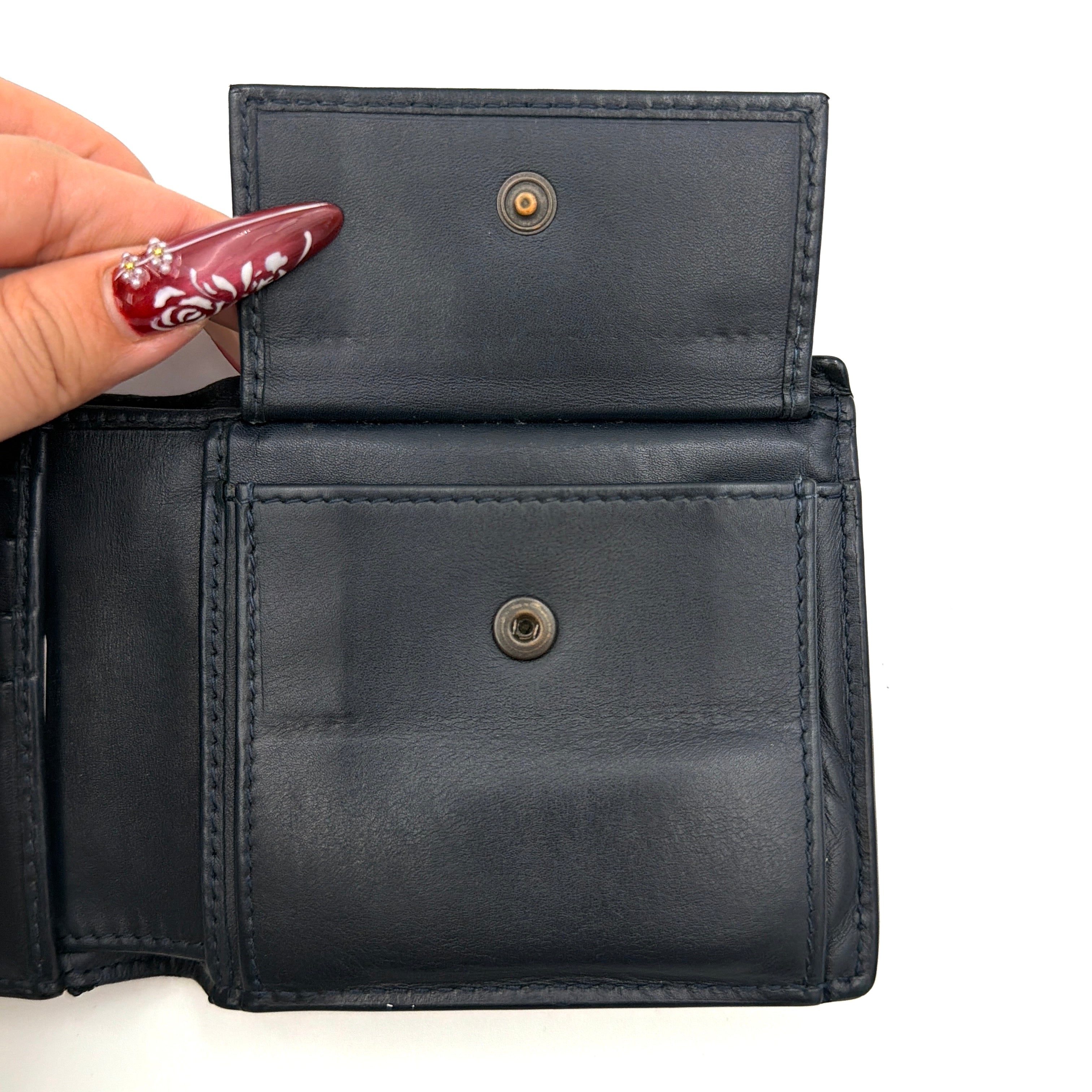 Black Bottega Veneta Intrecciato leather wallet with signature woven pattern photographed against a clean background.