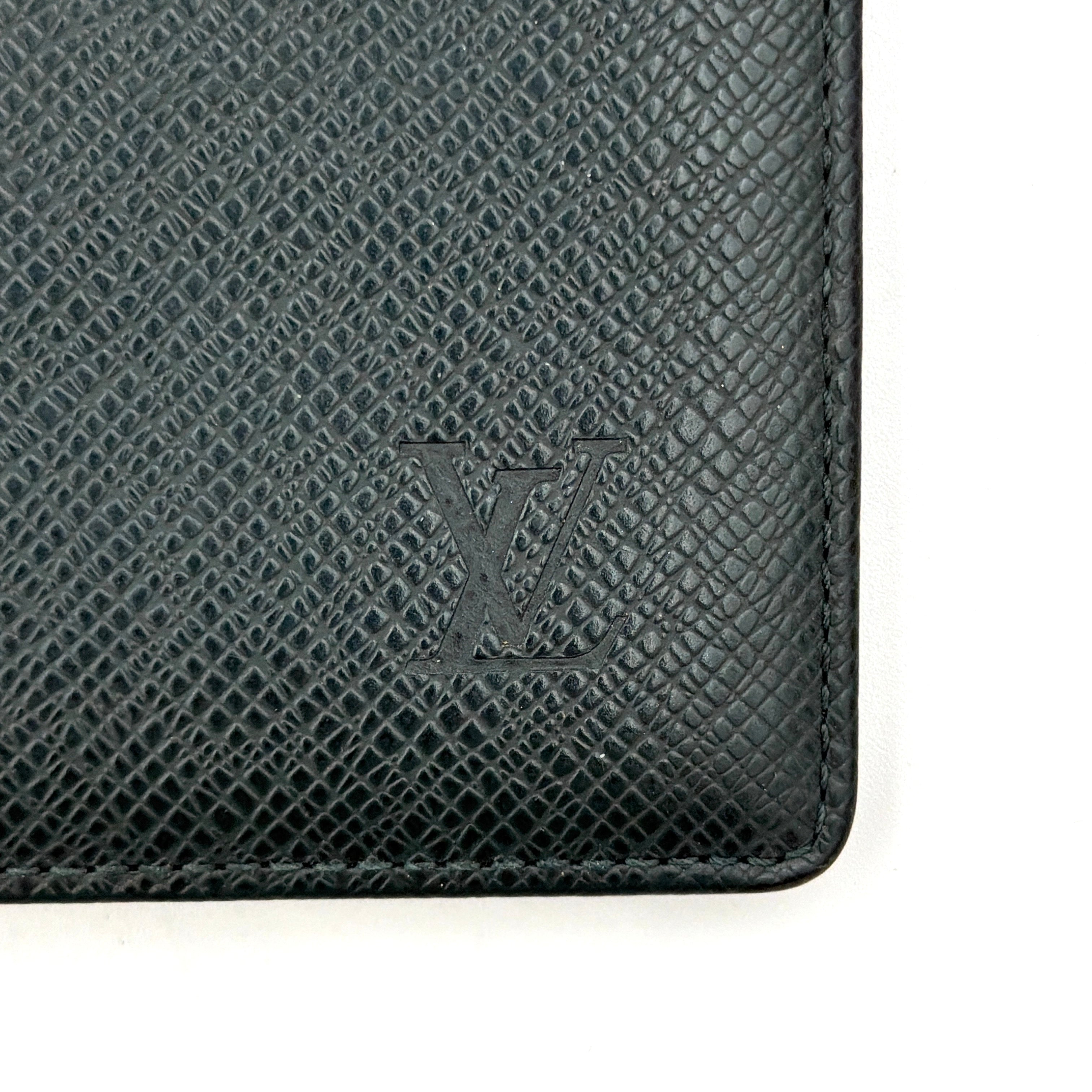A Louis Vuitton Taiga Brazza Wallet in dark green, showcasing fine cross-grain leather texture and the understated LV monogram debossed on the front.