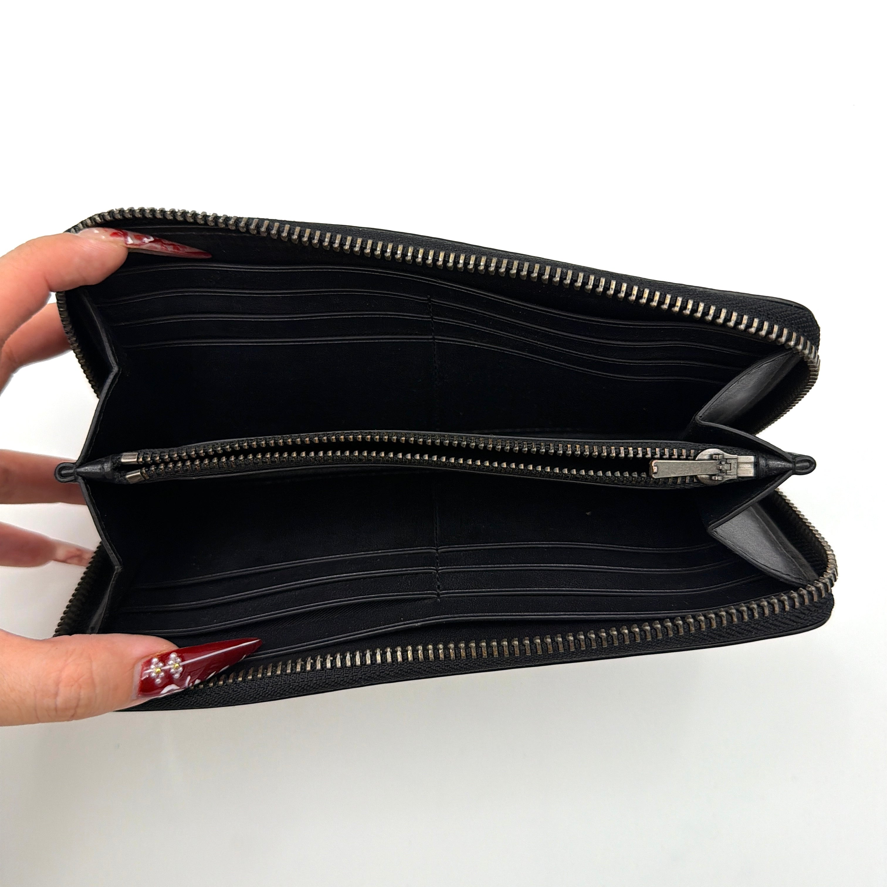 Coach Signature Accordion Long Wallet in beige and black canvas with black leather trim, featuring zip-around closure.